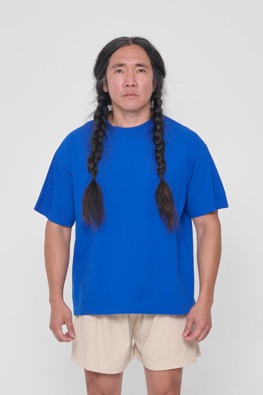 A 5'11" man in a size L Lapis blue Boxier Trash Tee. Bottom hem at the lower hip.