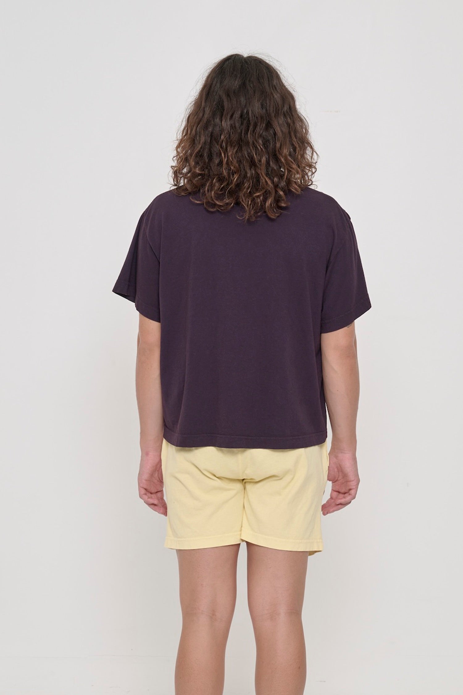Back view of Boxier Trash Tee in Mulberry dark purple showing fabric drape and relaxed fit throughout.