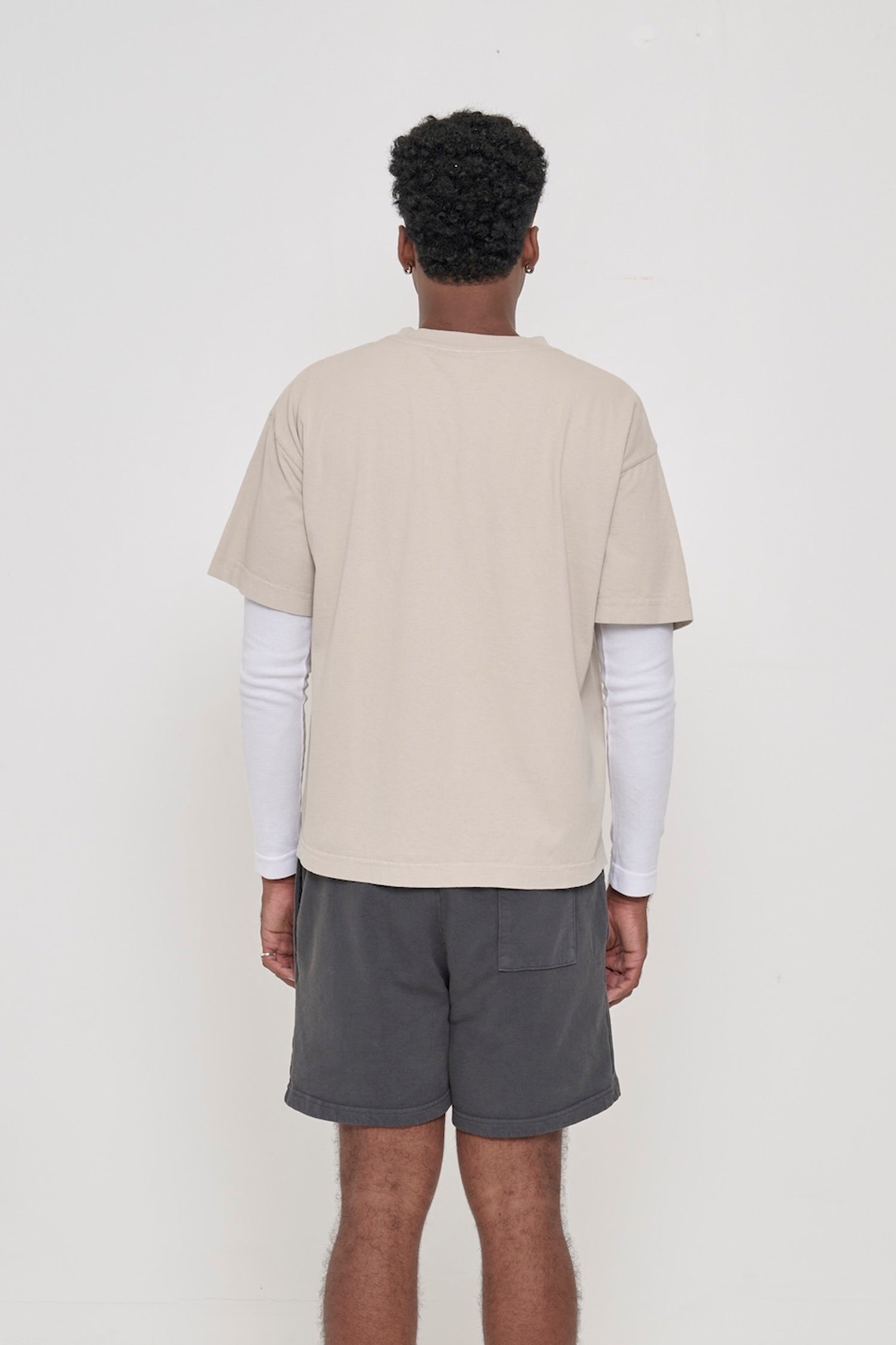 Back view of Boxier Trash Tee in Oat beige showing fabric drape and relaxed fit throughout.