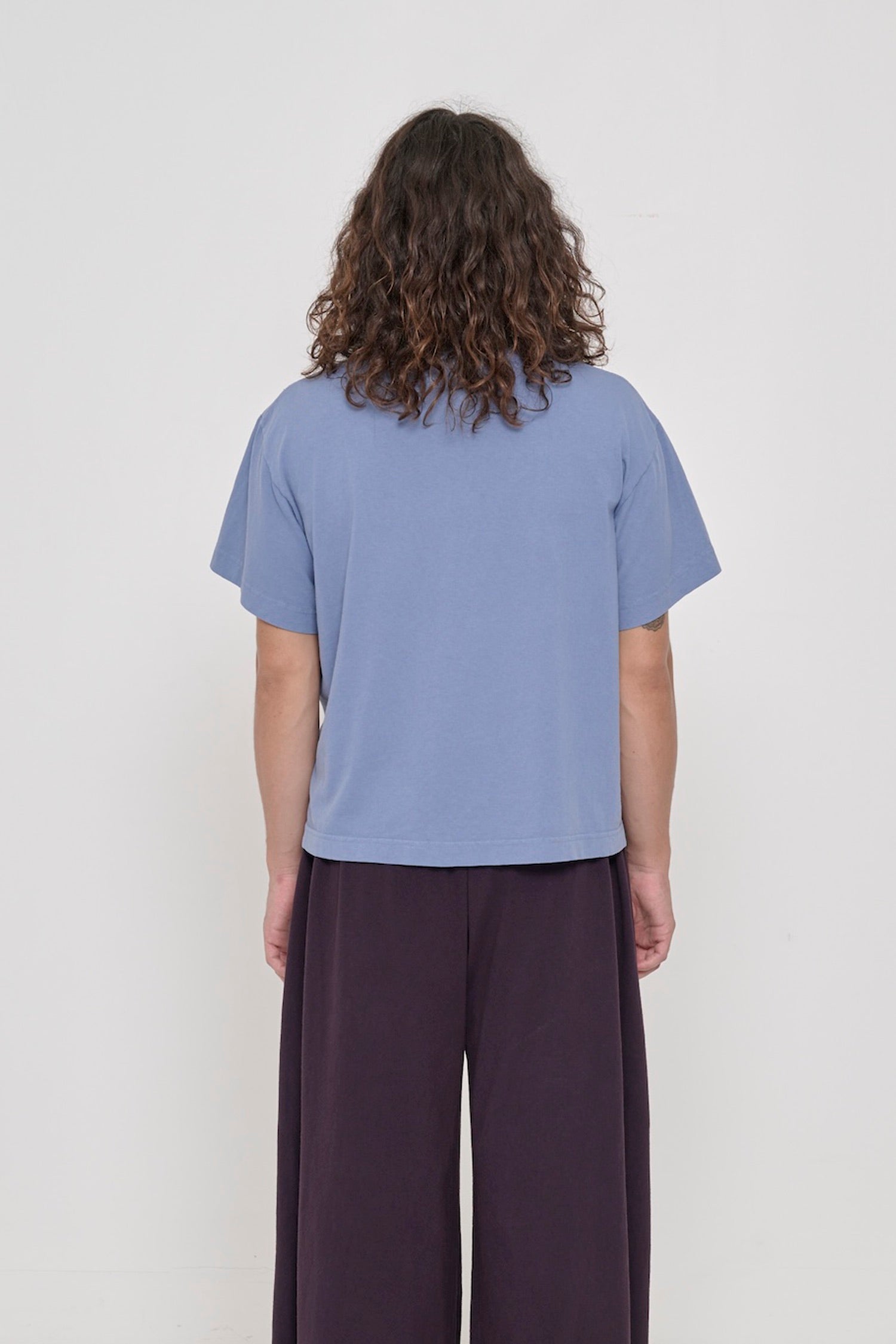 Back view of Boxier Trash Tee in Periwinkle light blue-purple showing fabric drape and relaxed fit throughout.