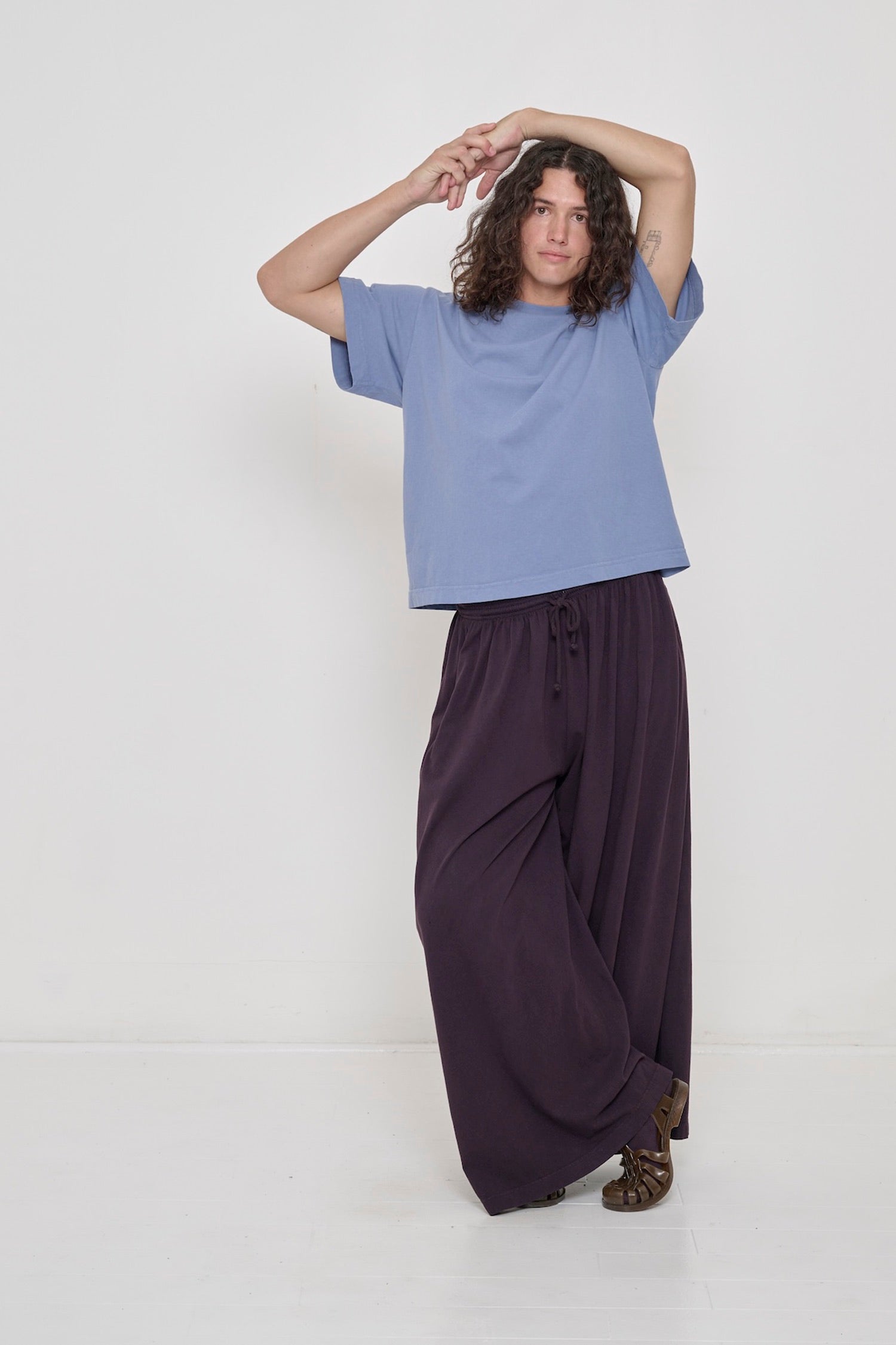 Person wearing Periwinkle light blue-purple Boxier Trash Tee with Mulberry Tubular Pants. 