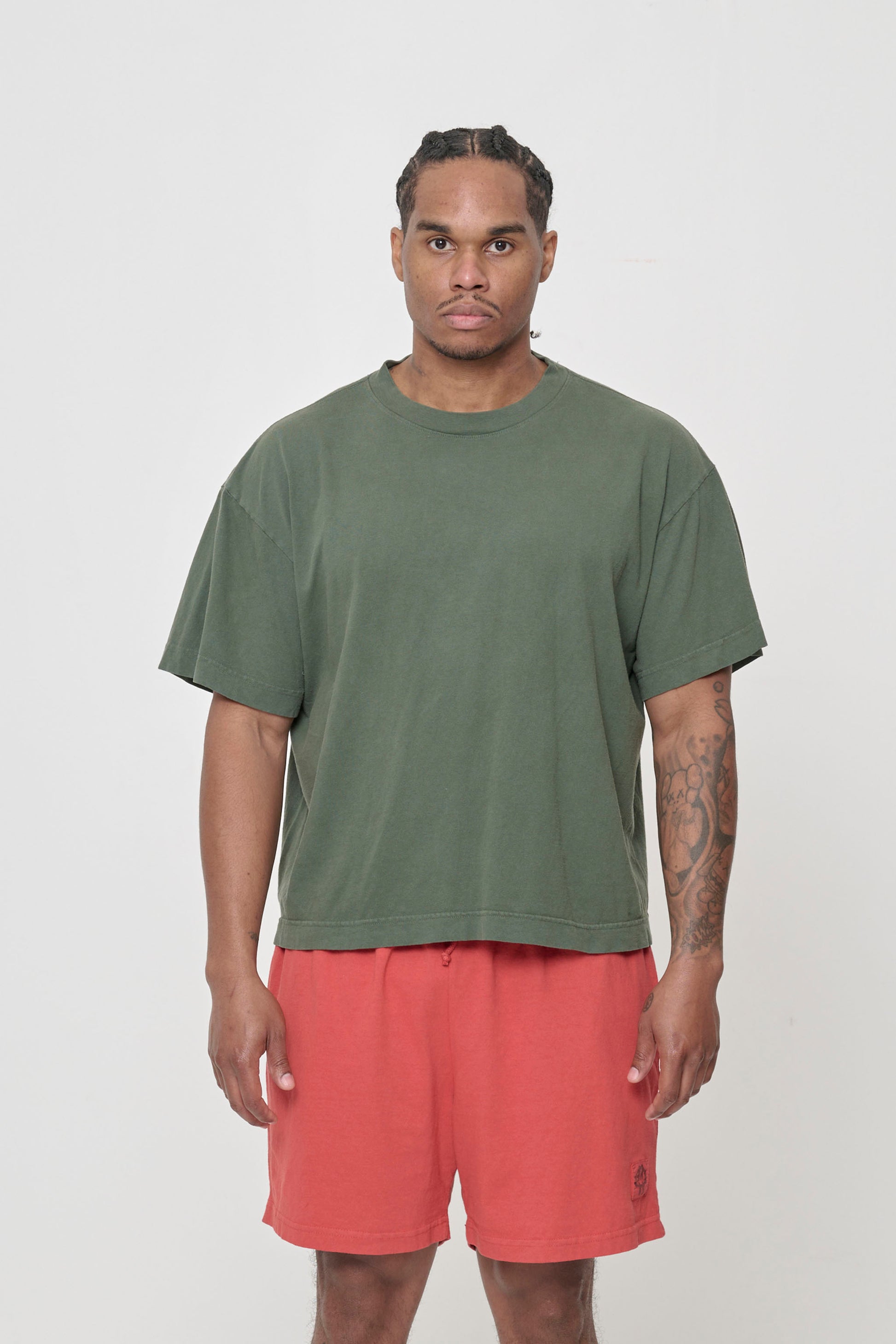 Front view of a 6-foot tall man wearing Pine (muted dark green) Boxier Trash Tee in size L.
