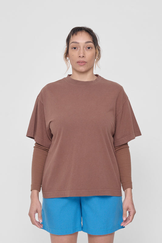 A 5'4" woman in a size M Potting Soil Boxier Trash Tee. Hem at her lower hip.