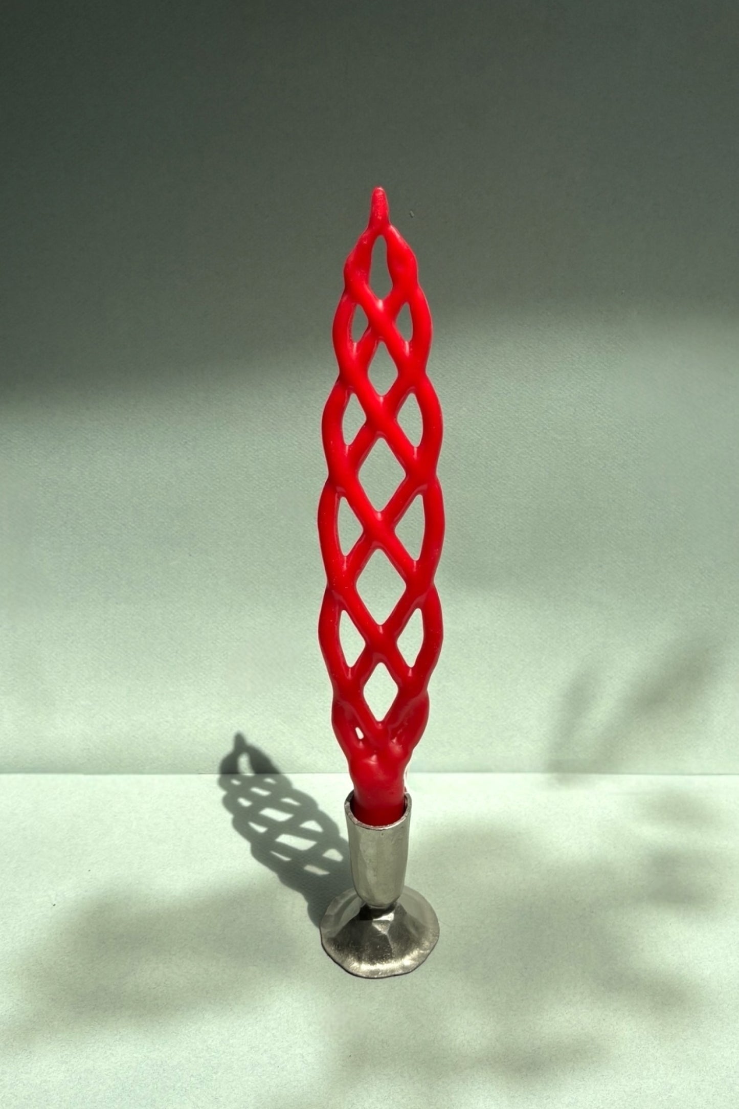 Red woven candle on a gray background