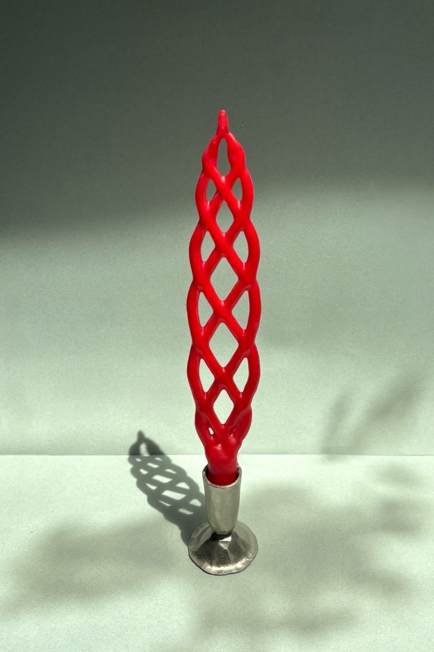 Red woven candle on a gray background