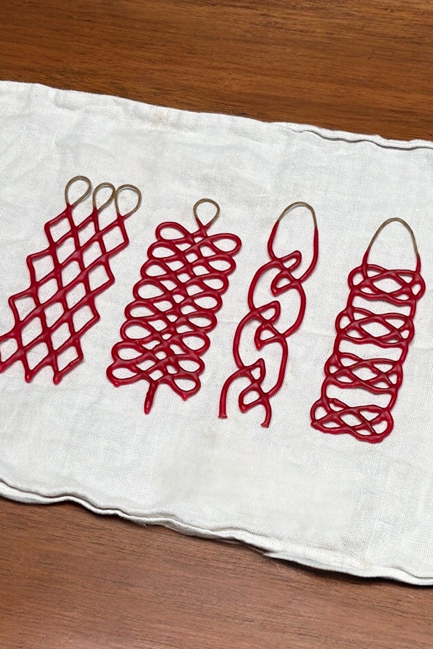 White towel with red braided candles on a wooden surface