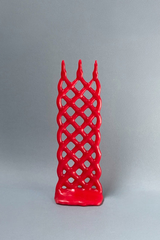 Red lattice-patterned candle on a gray background