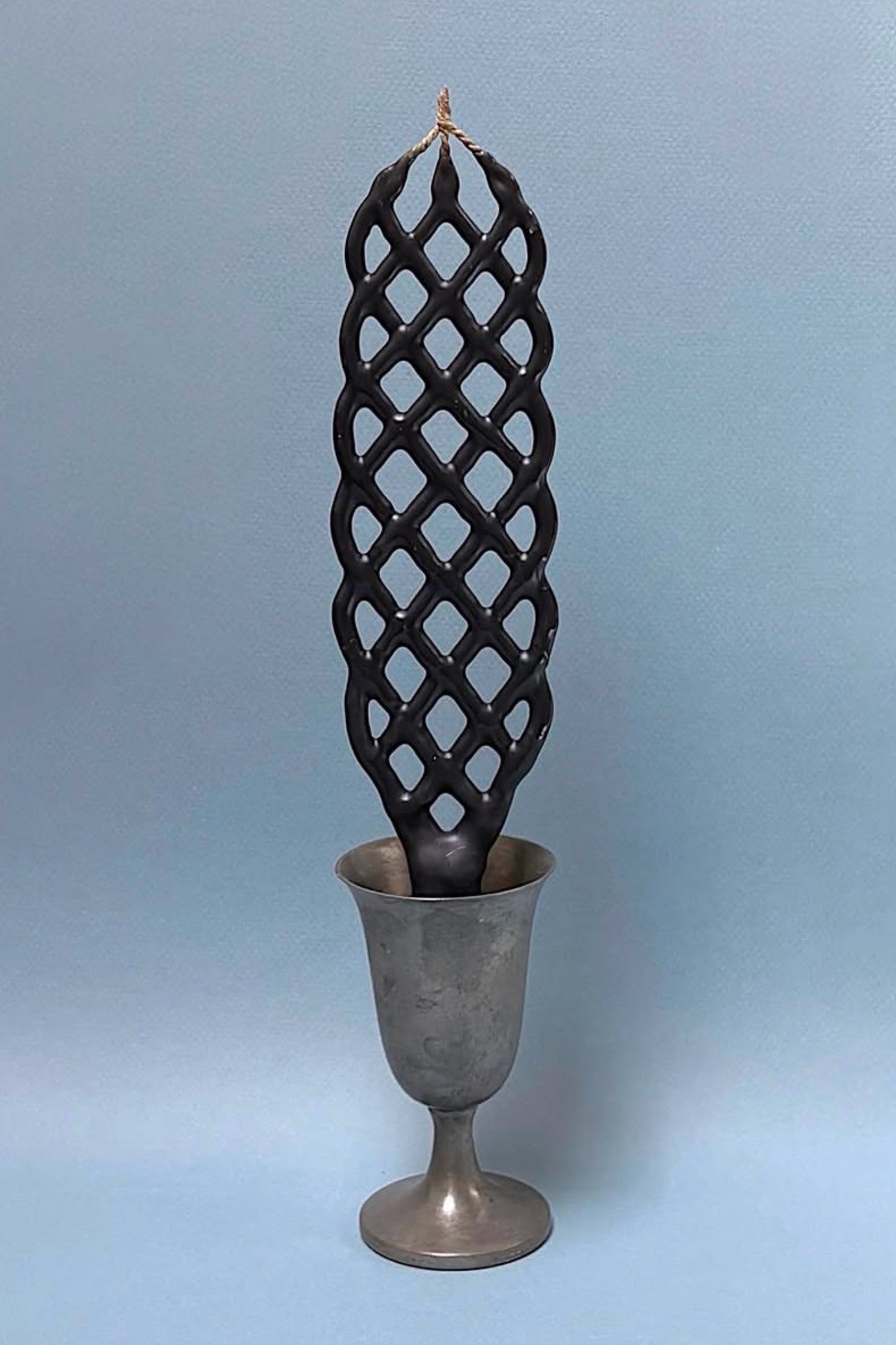 Slate lattice-patterned candle on a gray background