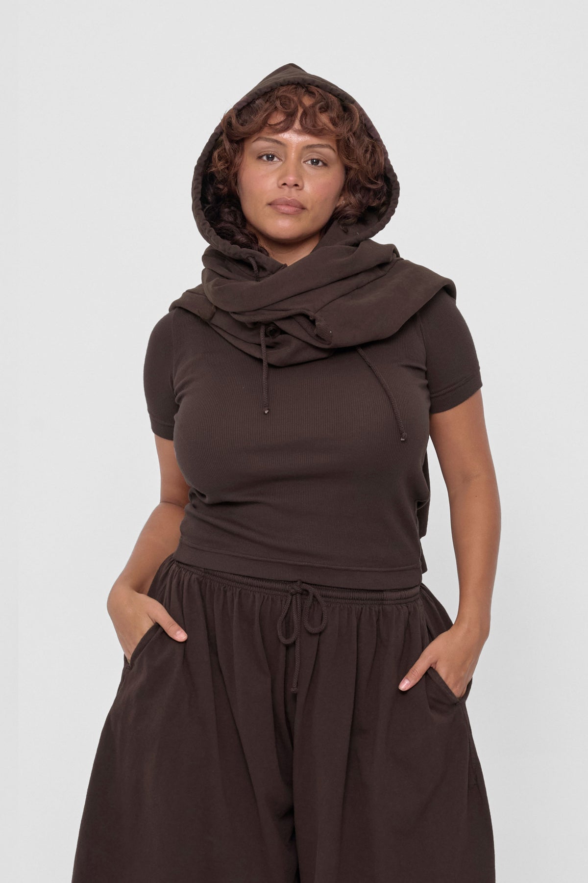Clyde x Everybody.World Hoodie Scarf in Wet Soil – front view on model, worn with hood on and sleeves wrapped around neck