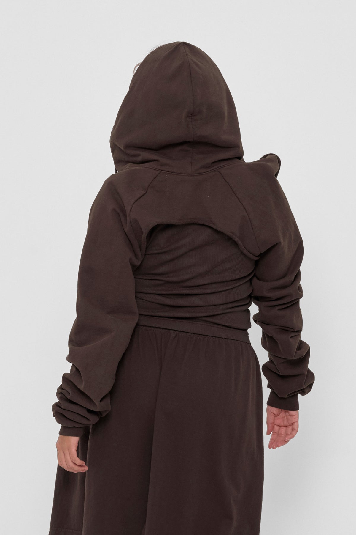 Clyde x Everybody.World Hoodie Scarf in Wet Soil – back view on model, hood up and arms through sleeves