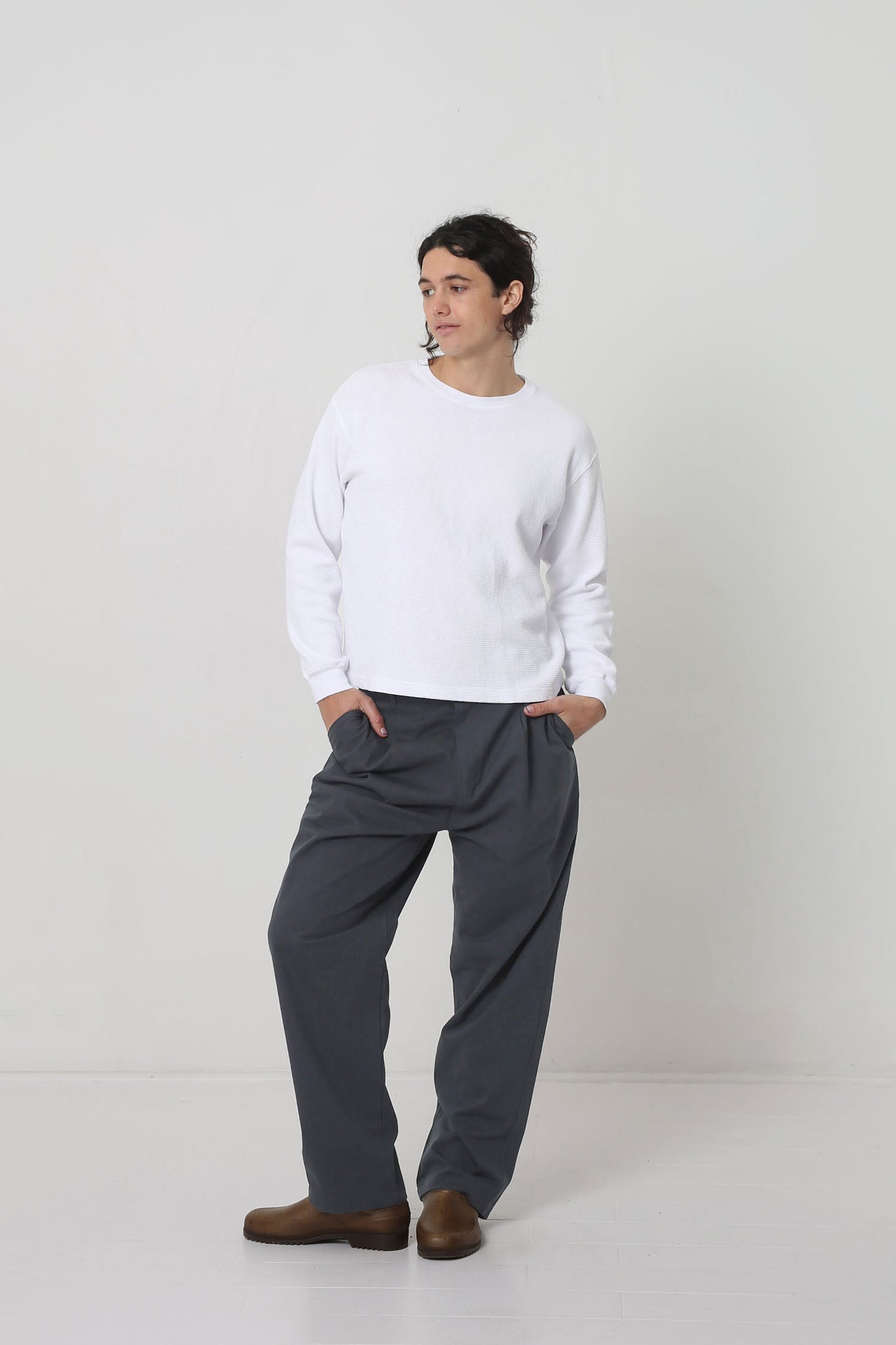 Styled with a White Long Sleeve Boxier Trash Tee. Hands in pants pockets.