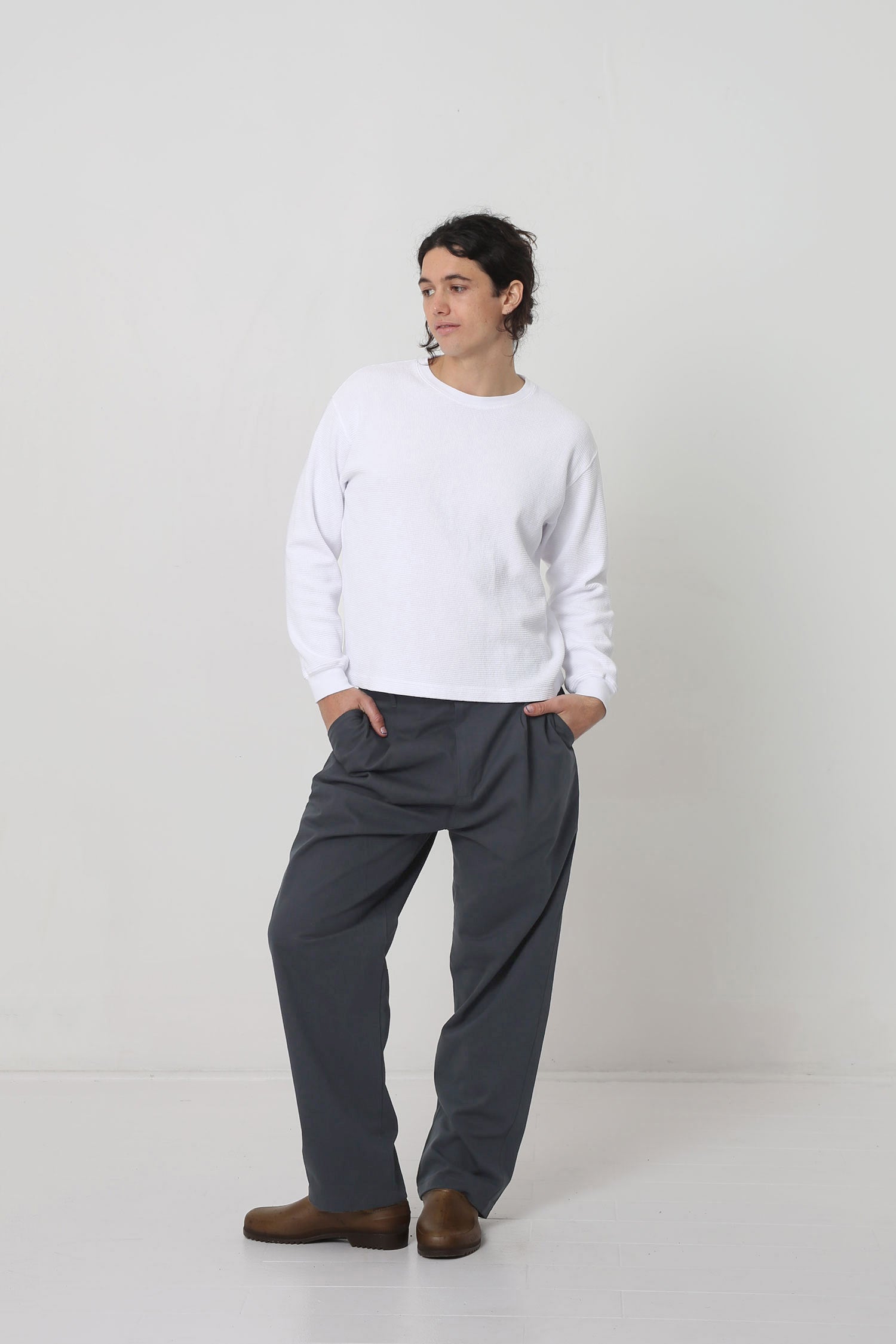 Styled with a White Long Sleeve Boxier Trash Tee. Hands in pants pockets.