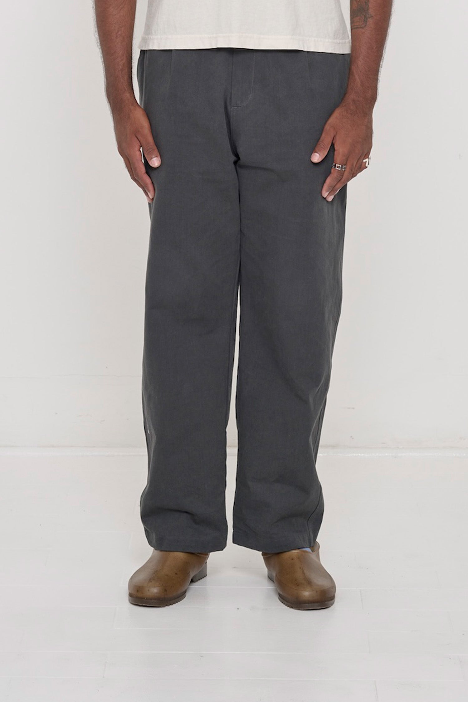 Bottom half of a person wearing Slate Cotton Twill Life Uniform Pants, showing the relaxed slim silhouette and zip-fly.