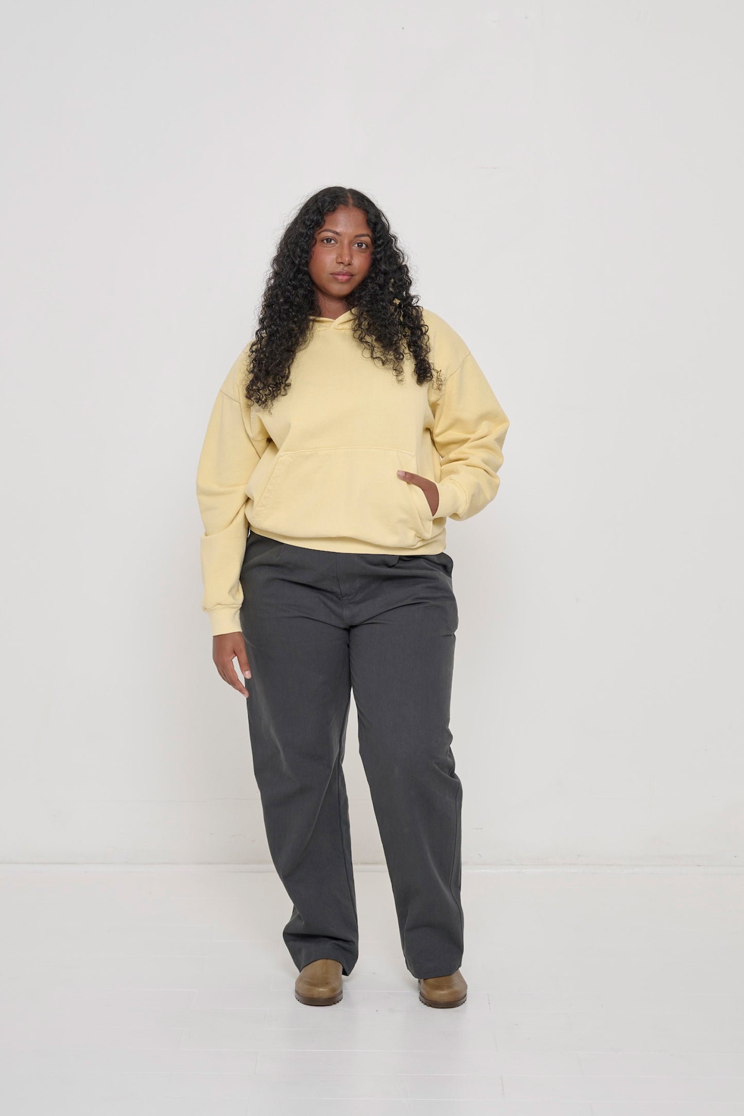 Full length view of a 5'8" tall person wearing Cotton Twill Life Uniform Pants in Slate and a Trash Crewneck.