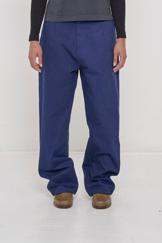 Bottom half of a person in Washed Navy Cotton Twill Life Uniform Pants. Shows relaxed silhouette and front pleats.
