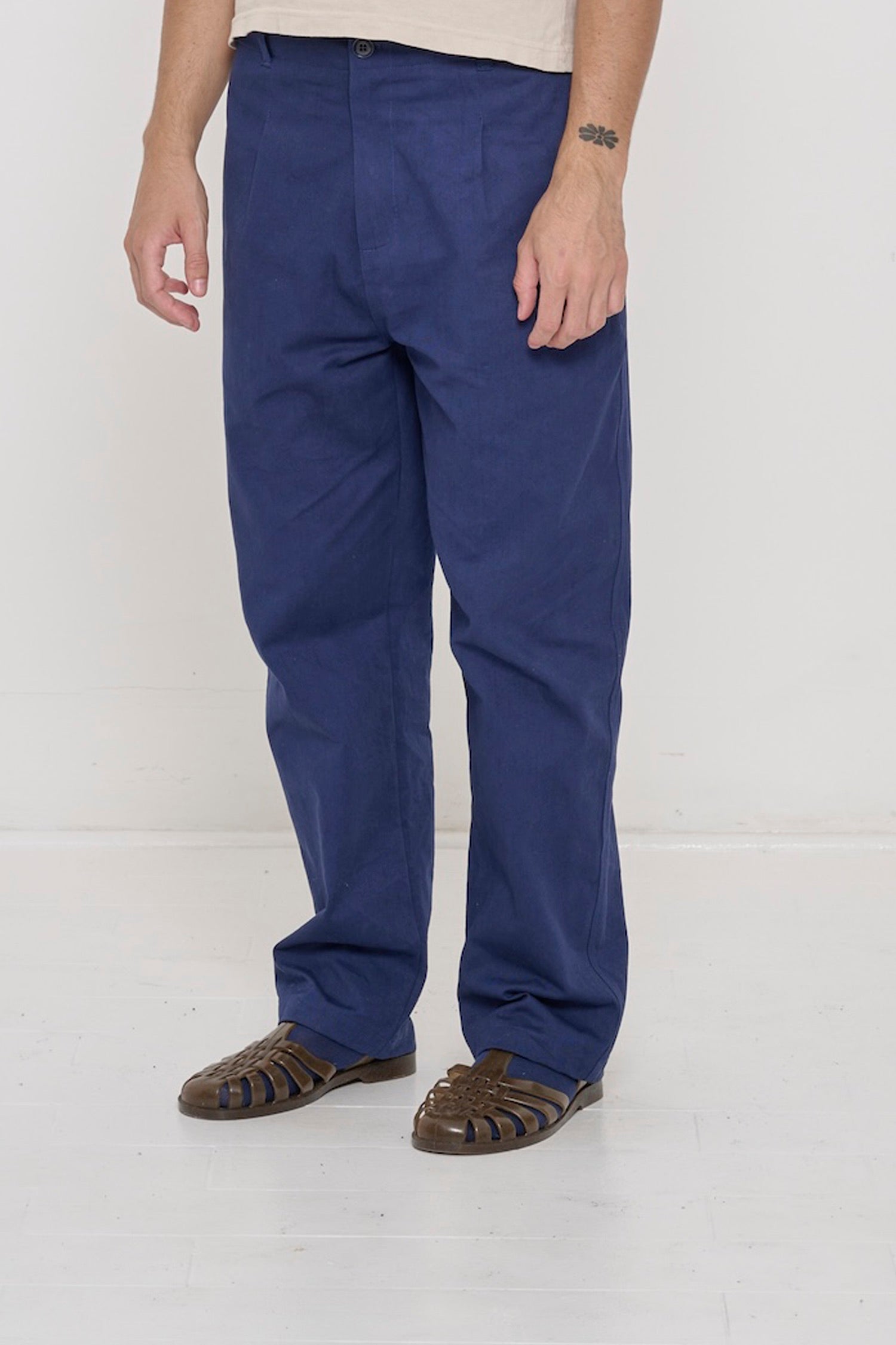 Bottom half of a person turned  45-degrees, wearing Cotton Twill Life Uniform Pants in Washed Navy showing the inseam and outseam.