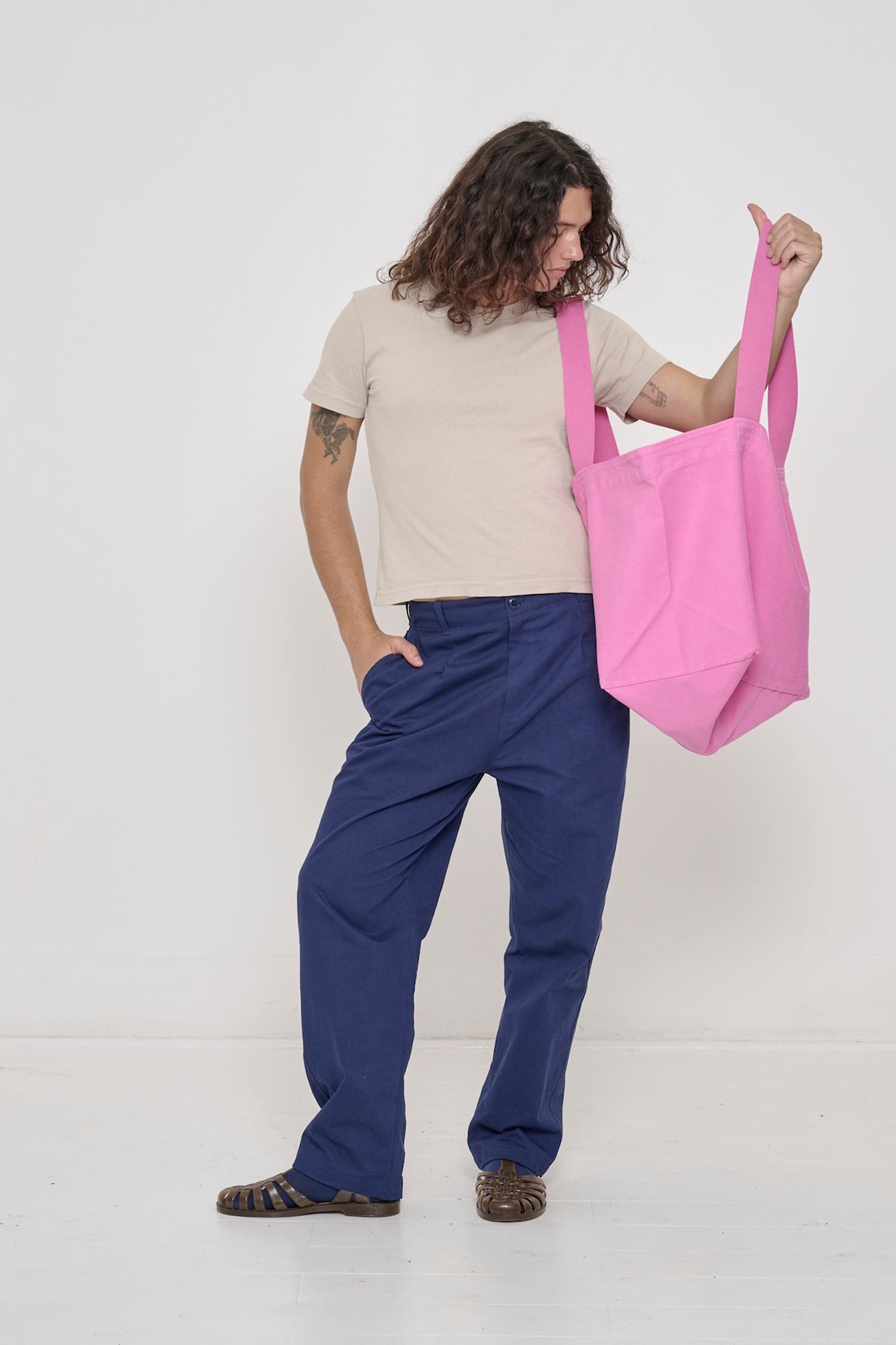 6' person in Washed Navy Cotton Twill Life Uniform Pants (hem at heel) and a Tailored Trash Tee, holding a Big Tote.