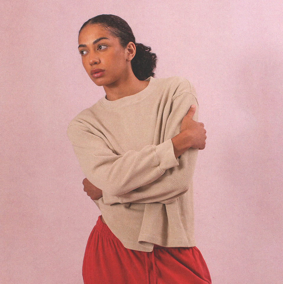 Person with their arms crossed, wearing Thermal Long Sleeve Boxier Trash Tee and Apartment Pants in Cedar.