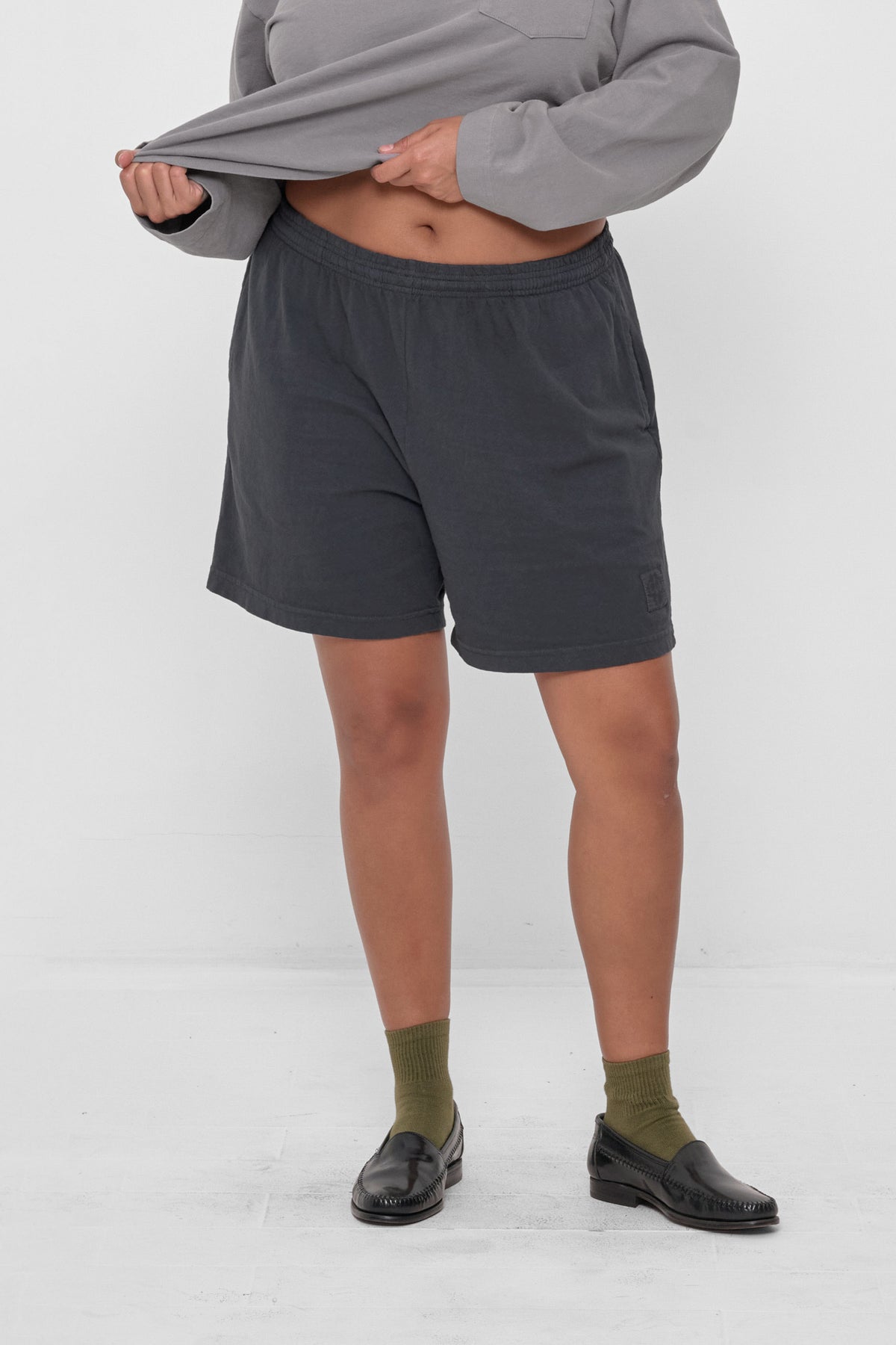 Everyday Shorts in Slate - front view, model's hands adjusting Rugby Trash Polo