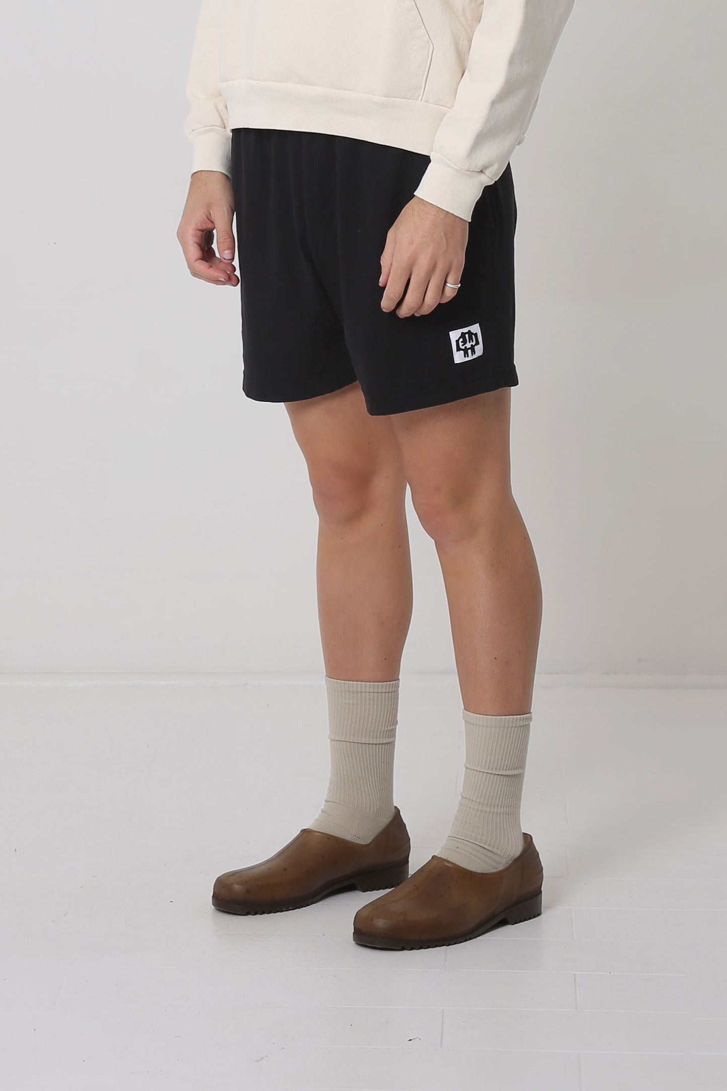 Waist down of body facing 45-degrees from the front, highlighting black and white logo.