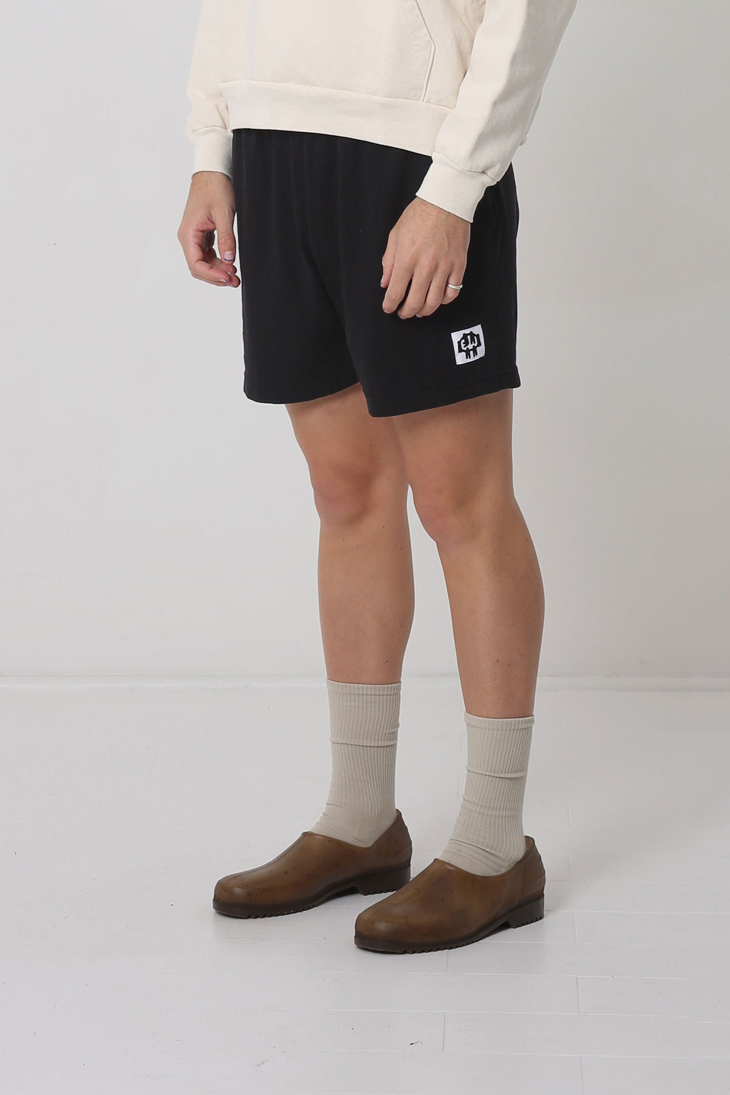 Waist down of body facing 45-degrees from the front, highlighting black and white logo.