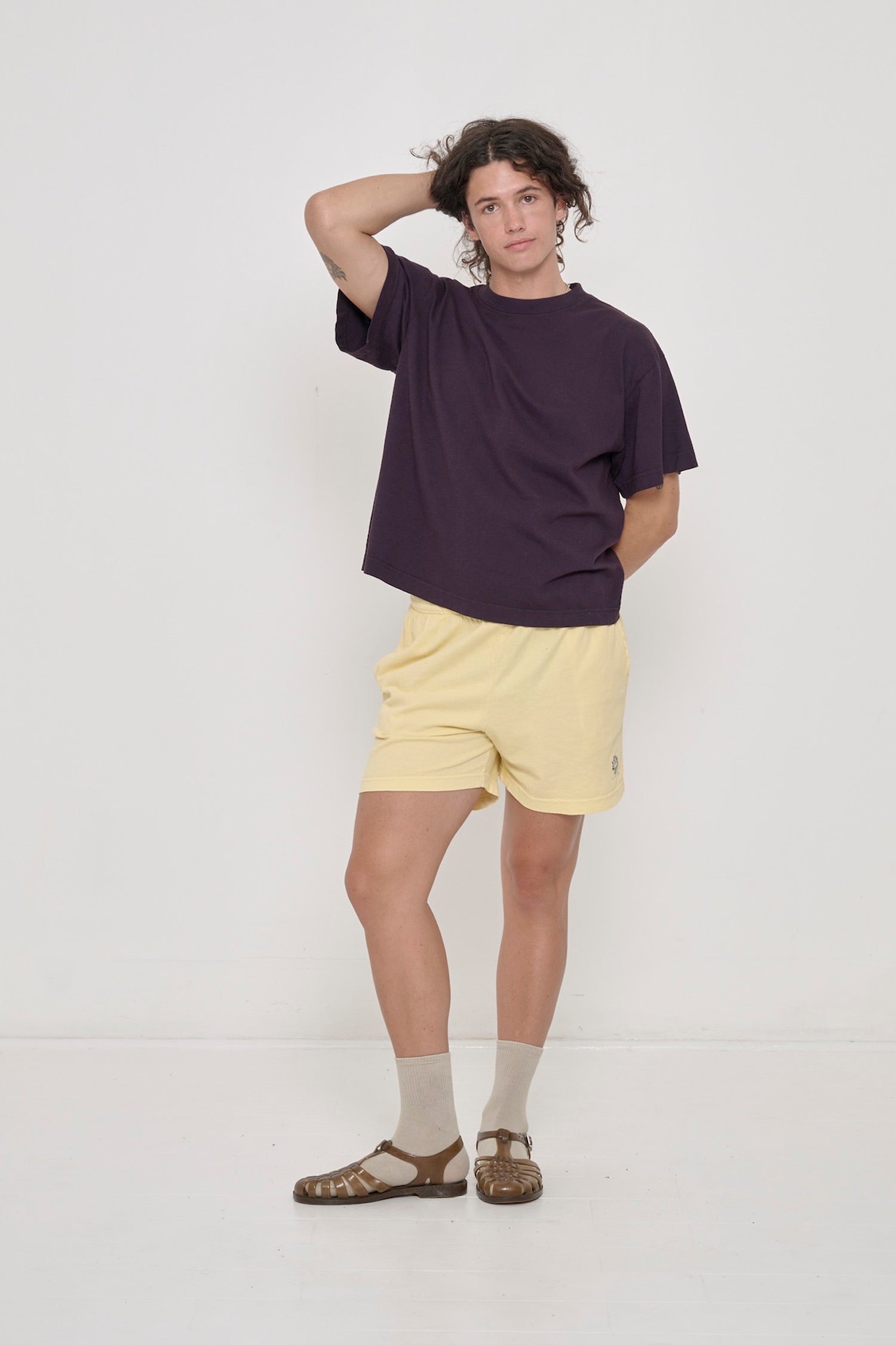 A person in a Mulberry Boxier Trash Tee and French Butter Everyday Shorts. Right knee popped to the side, showing inseam.