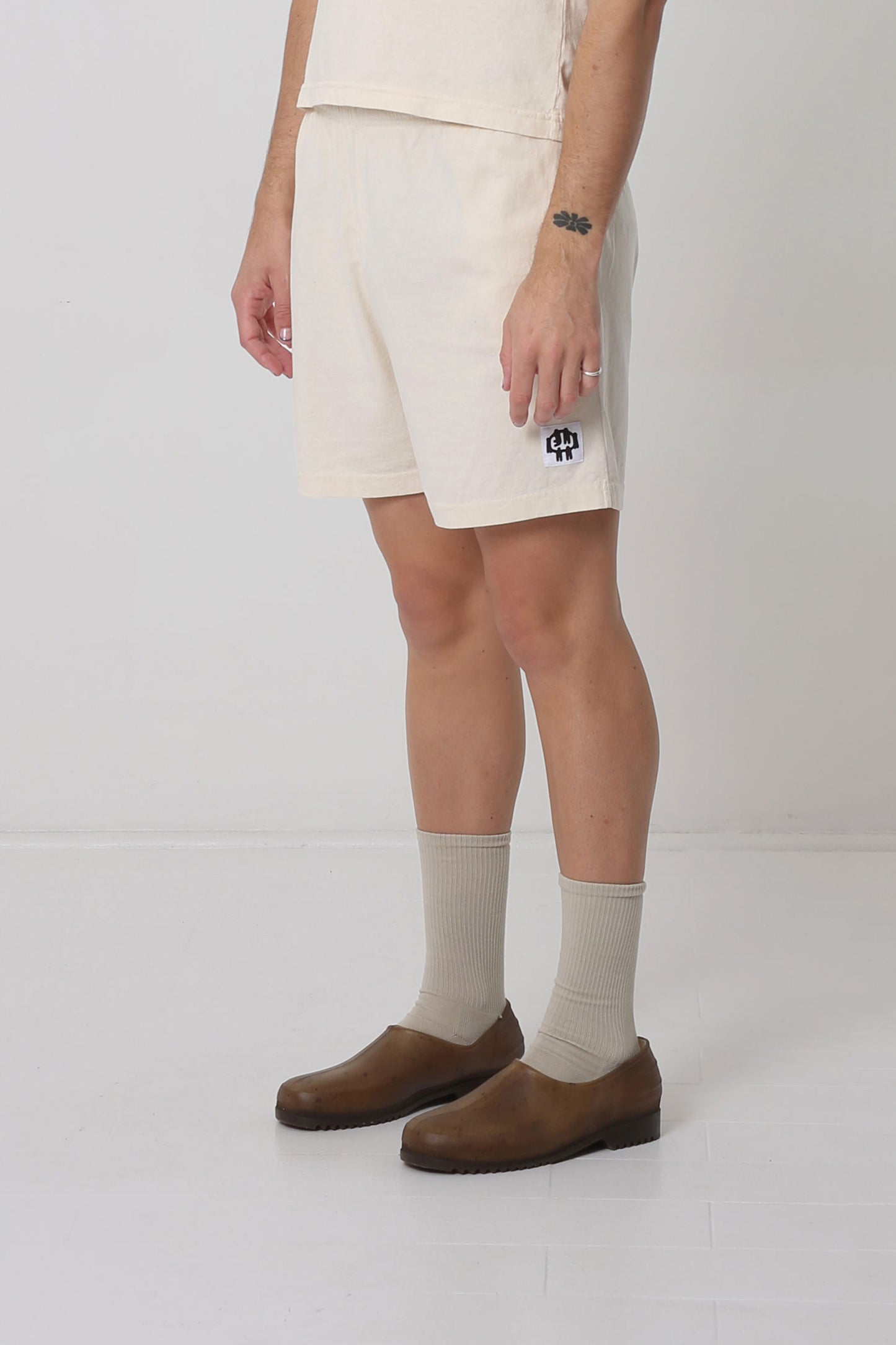 Waist down of body facing 45-degrees from the front, highlighting black and white logo.