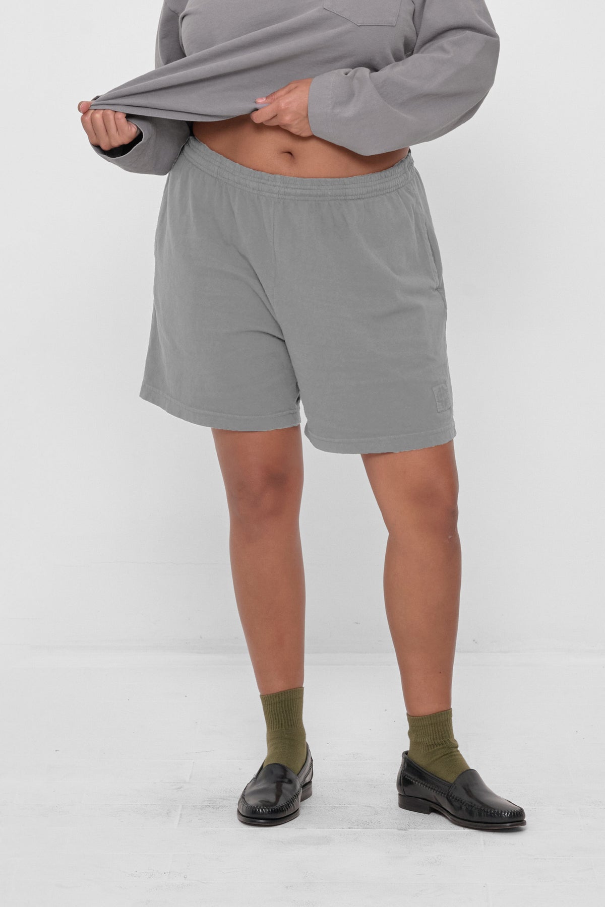 Everyday Shorts in Stone - front view, model's hands adjusting Rugby Trash Polo