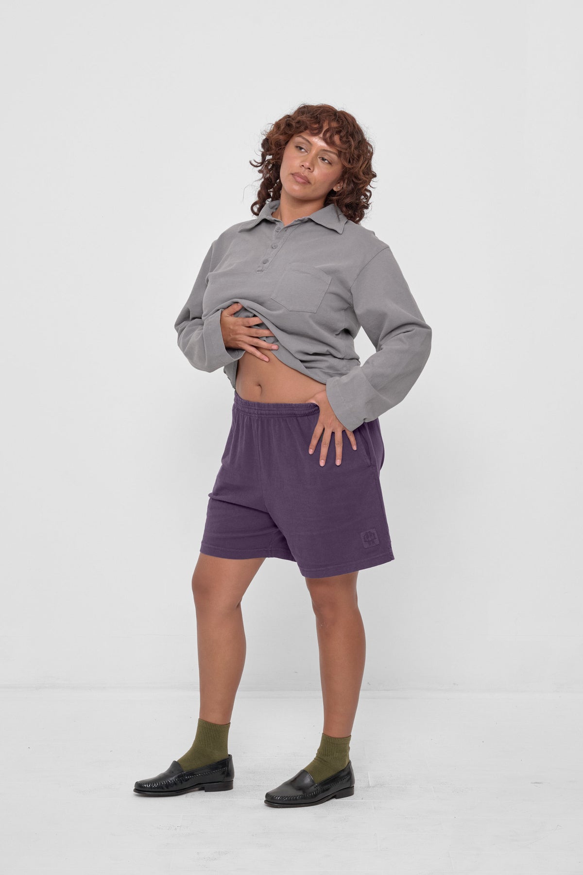 Everyday Shorts in Stone - front full body view, model's hands adjusting Rugby Trash Polo, styled with Stone Rugby Trash Polo, Olive Squishy Socks, and loafers.