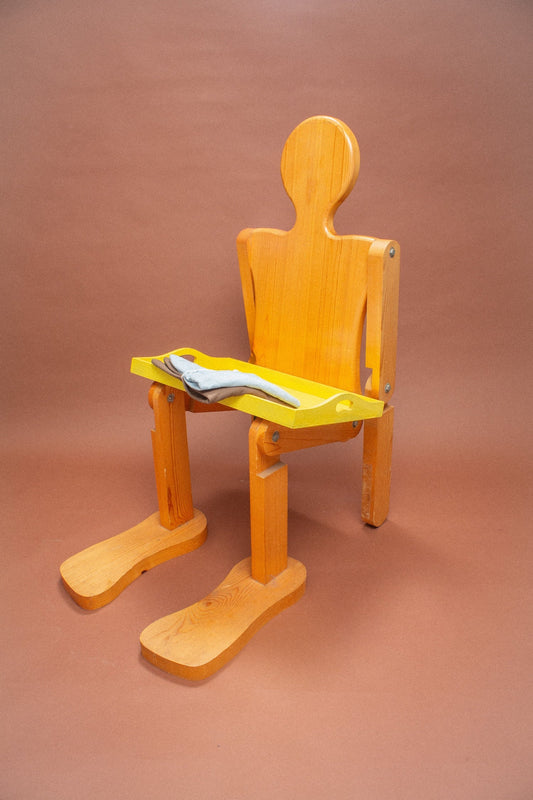 Wooden mannequin chair with Soil and Fog (light blue) folded tees on its lap.