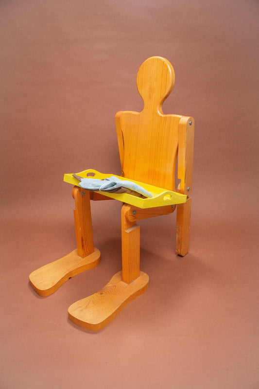 Wooden mannequin chair with Soil and Fog (light blue) folded tees on its lap.