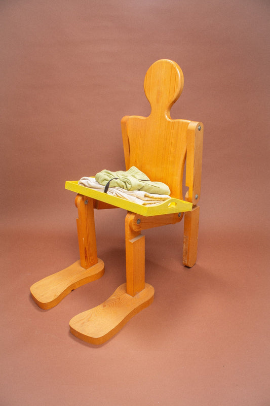Wooden mannequin chair with Cardamom light green shorts and Scour folded pants on its lap.