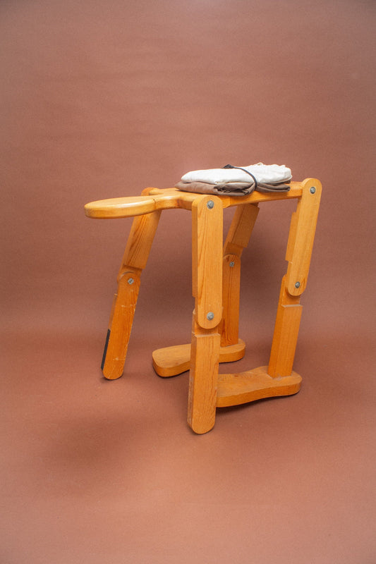 Wooden stool with folded Scour and brown tees on it.