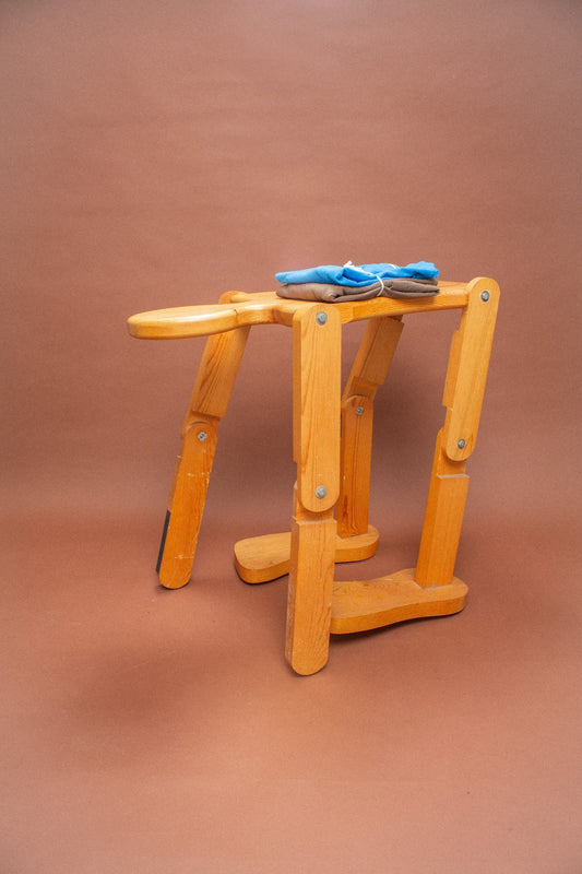 Wooden stool with a folded blue and brown tees