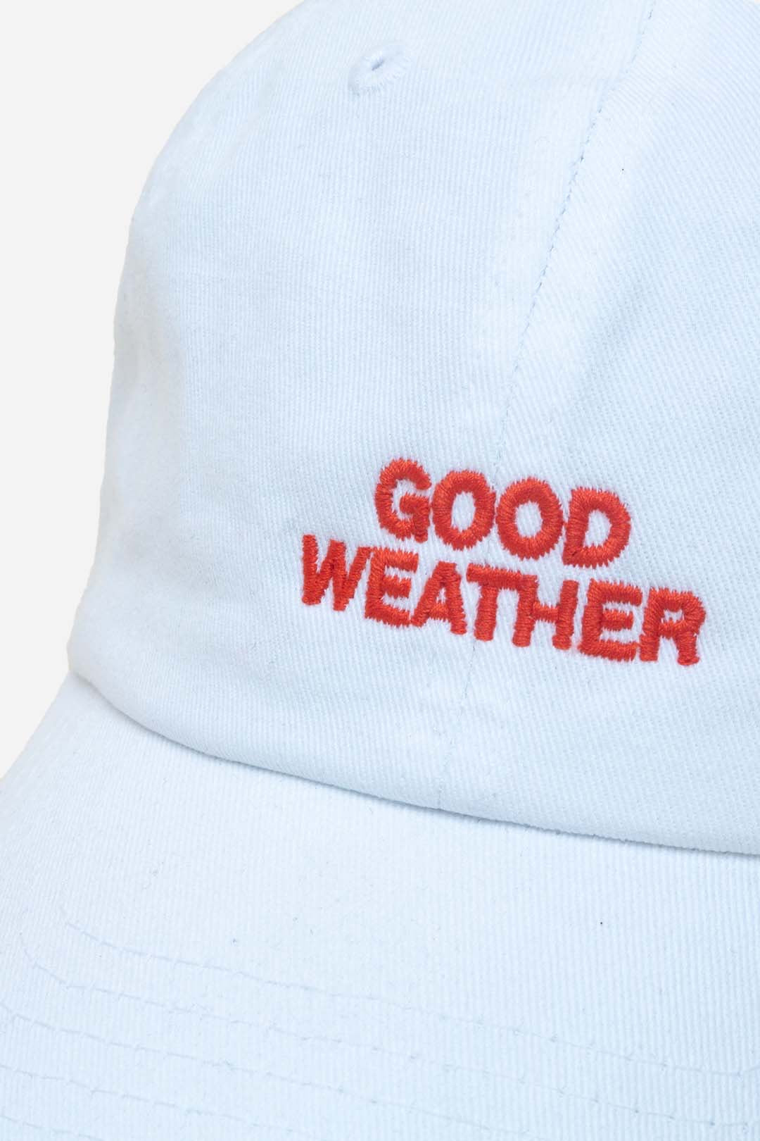 Close up of Good Weather Cap with 'GOOD WEATHER' embroidered in red on a light background