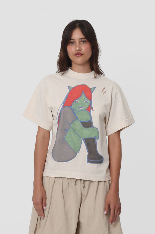 A 5'5" woman in a size XS Come Tees x Gold Star Boxier Trash Tee.  Hem ends at middle hip.