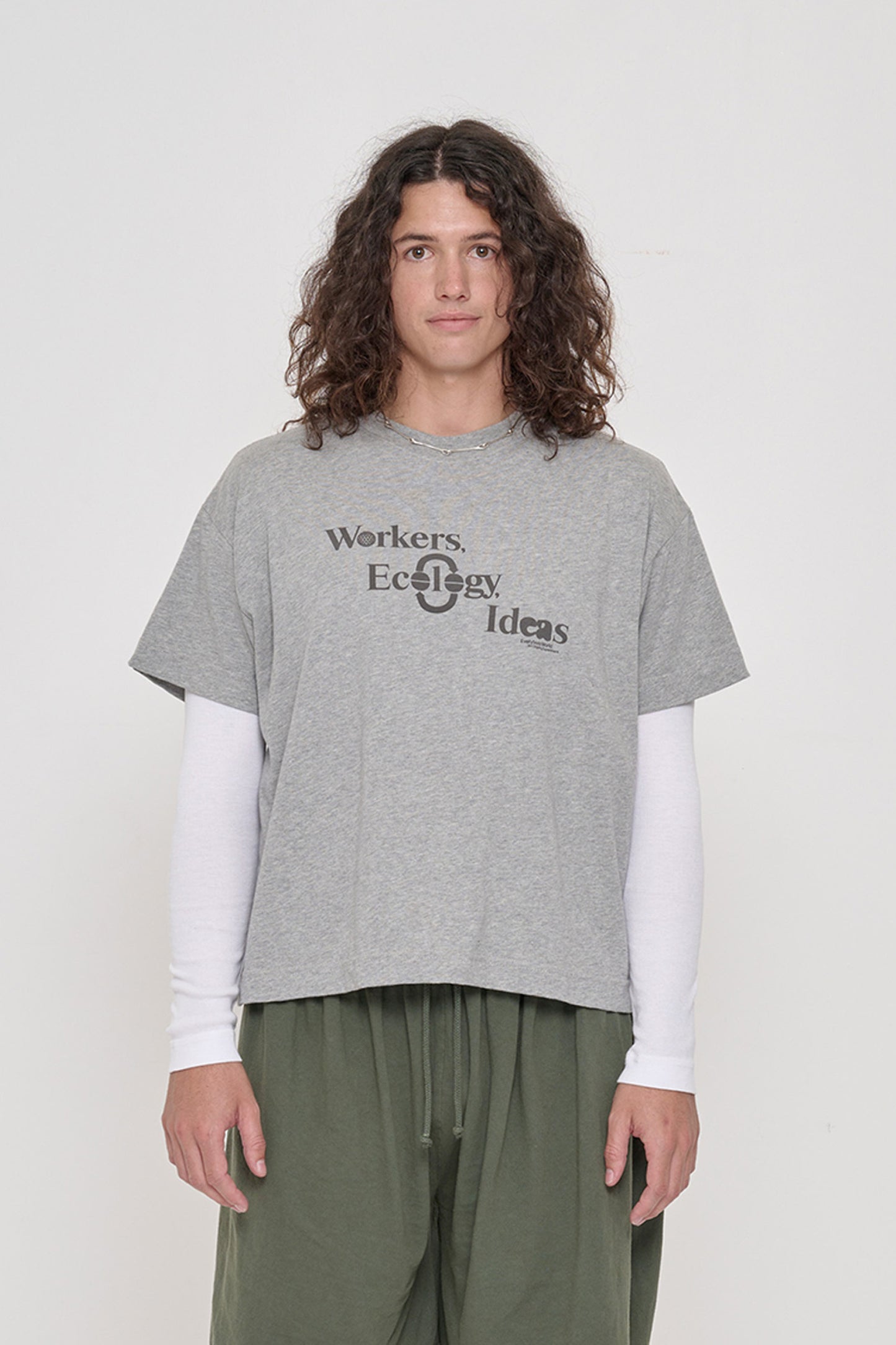 Person wearing Heather Boxier Tee that reads 'Workers, Ecology, Ideas' screenprinted on the front.