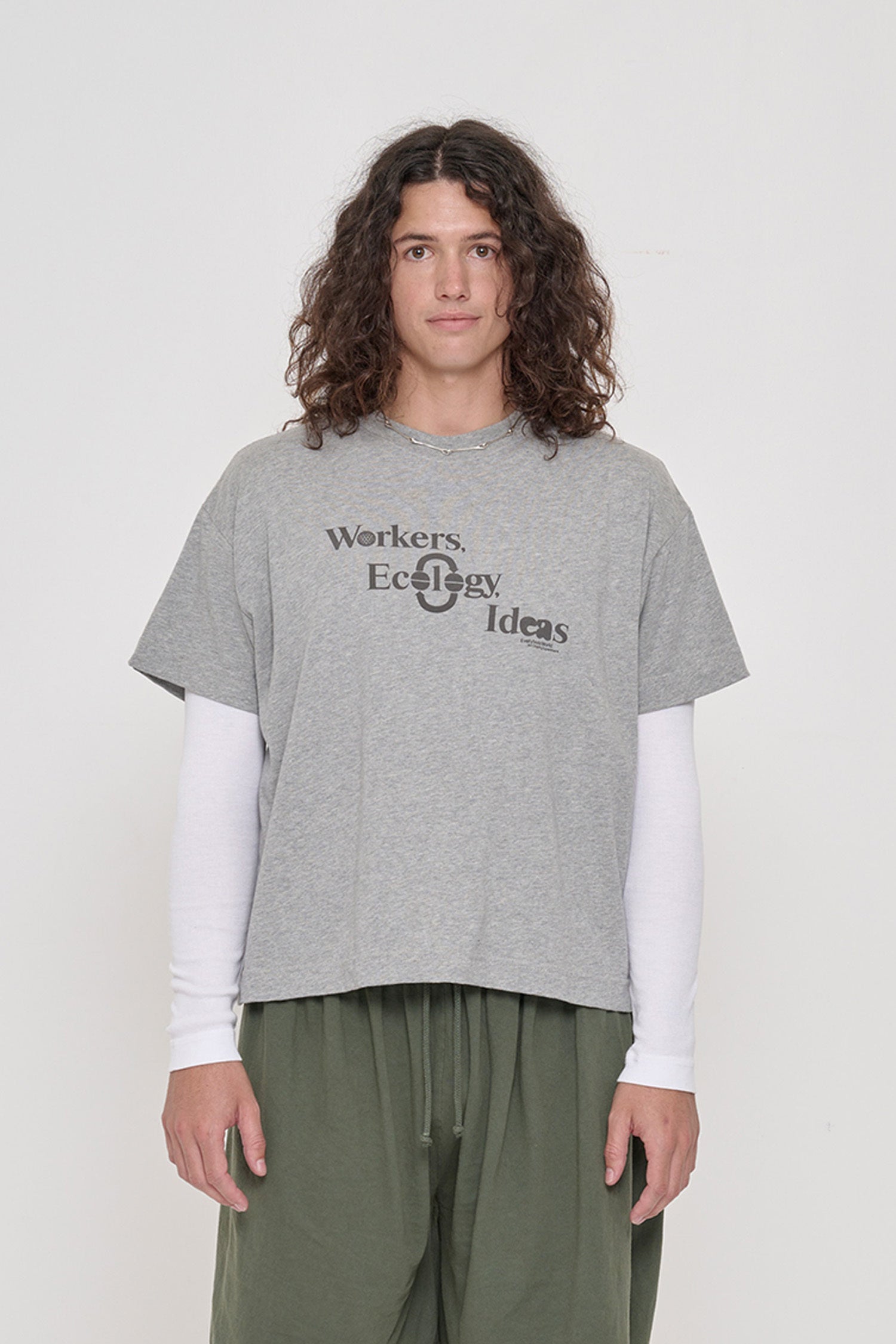 Person wearing Heather Boxier Tee that reads 'Workers, Ecology, Ideas' screenprinted on the front.