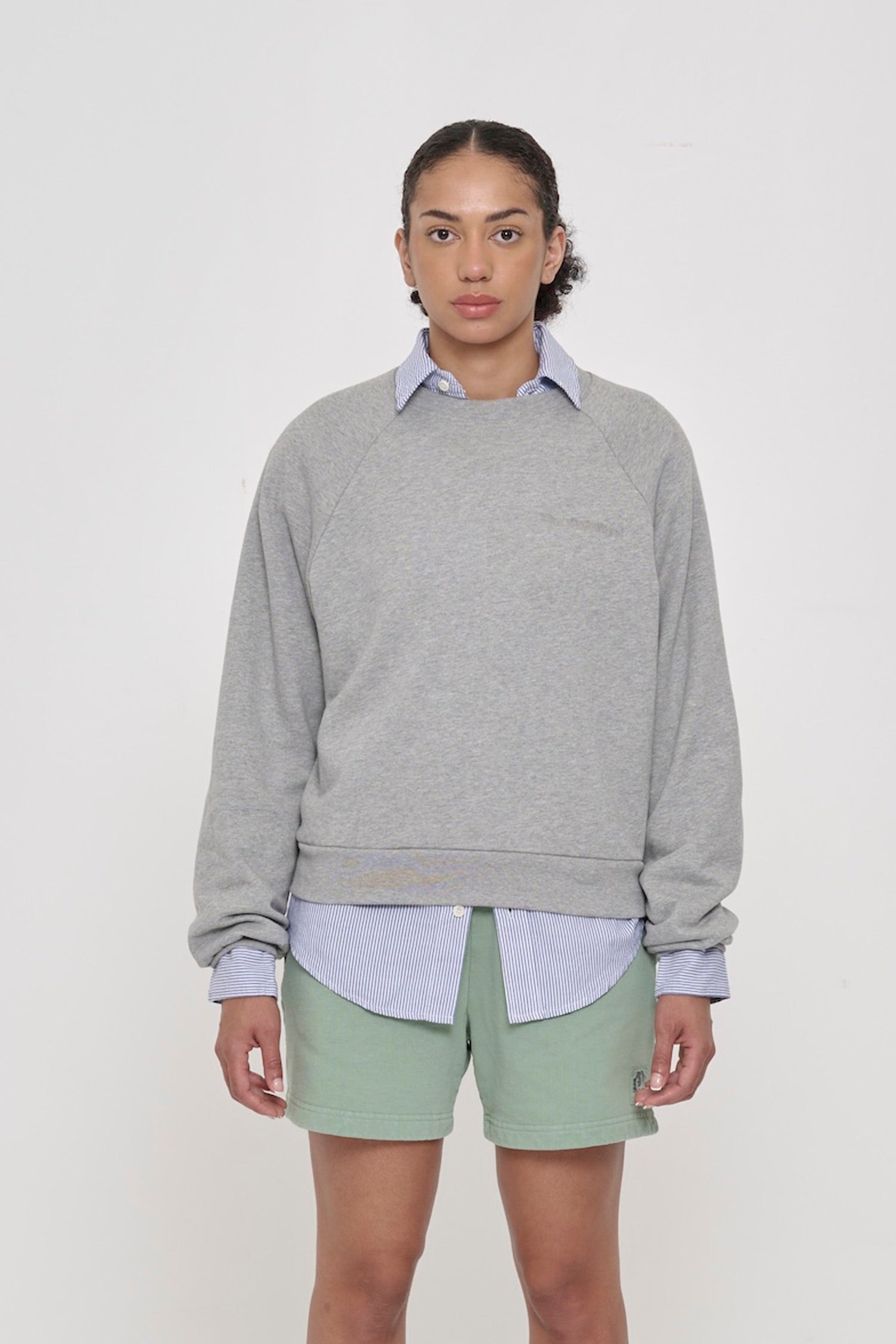 5'8" woman in Heather Raglan Sweatshirt in size M. Hem hits her upper middle hip.