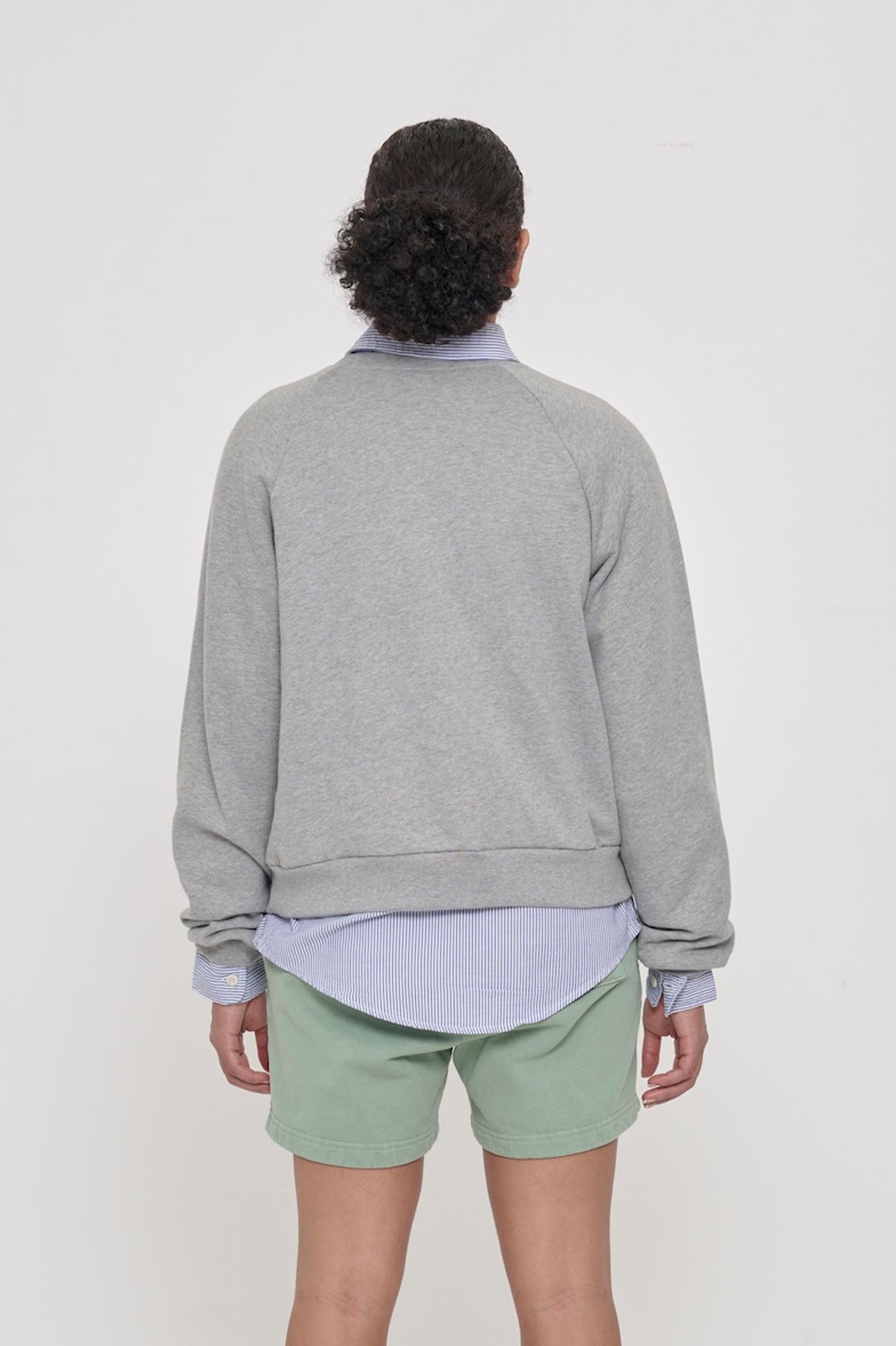 Heather Raglan Sweatshirt, back view on a person. Relaxed throughout. 