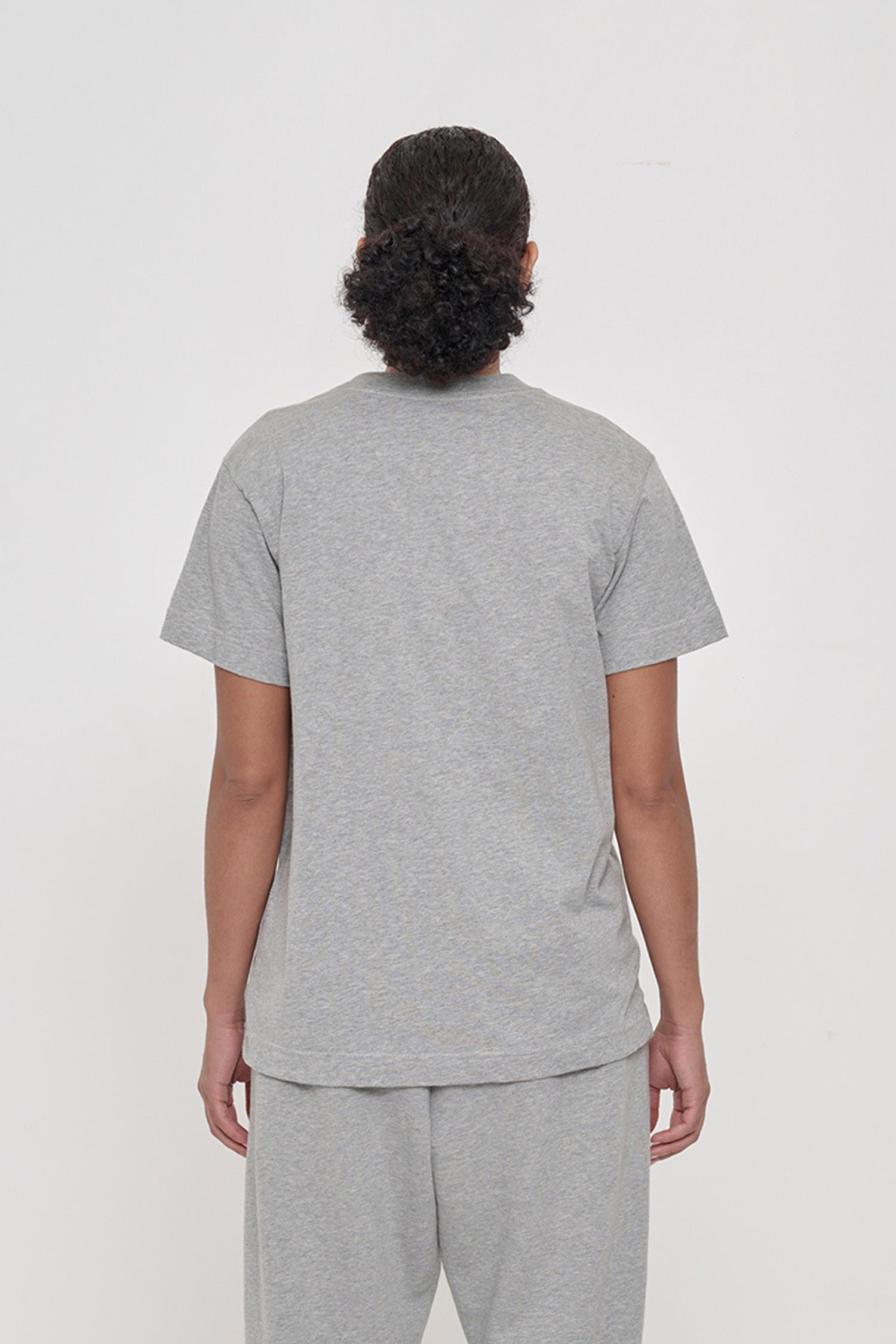 Back view of a woman in a Heather Short Sleeve Tee showing the relaxed fit throughout.