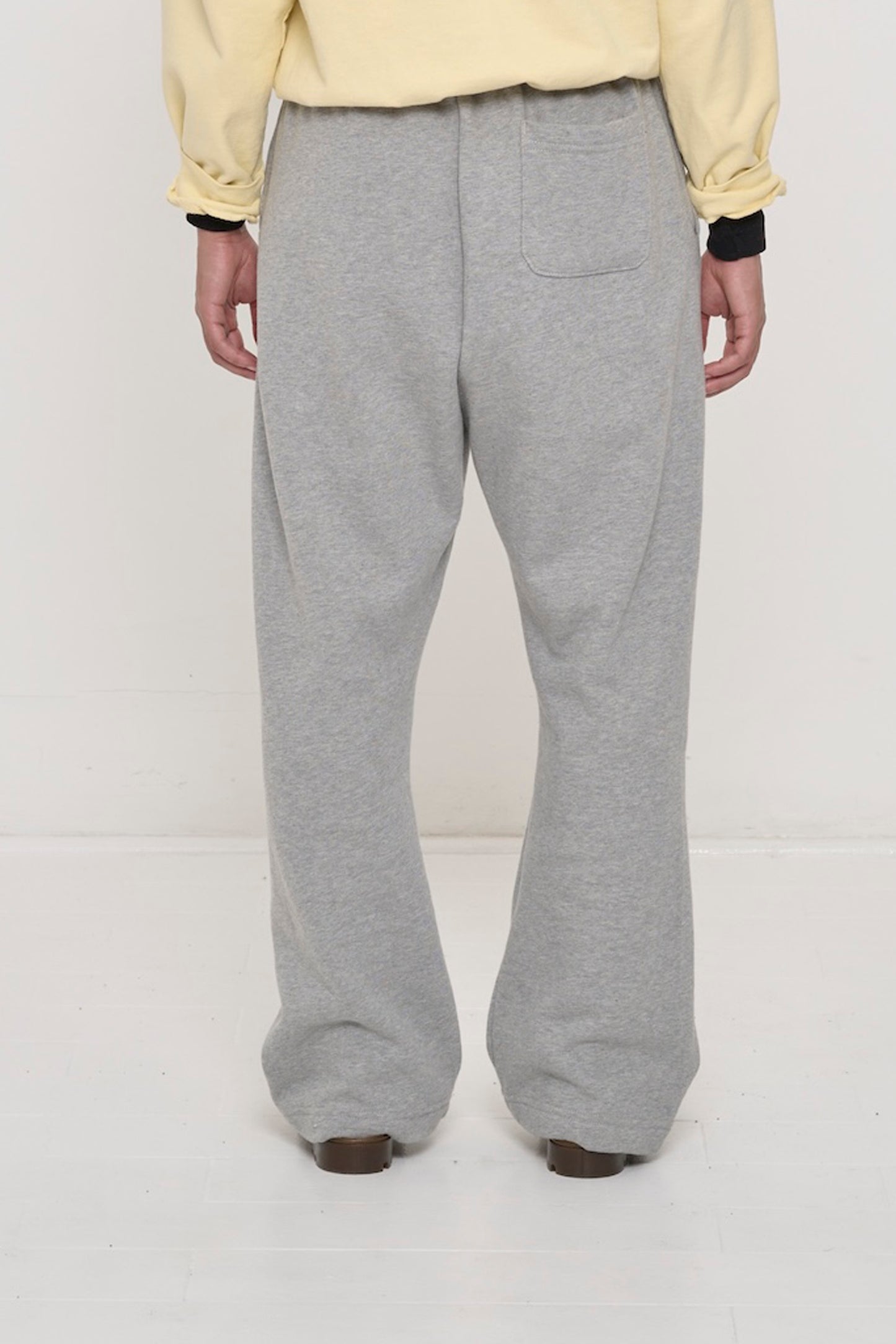 Back view: person in Heather Sweatpants sized up for a slouchy fit throughout. Right-side back pocket.