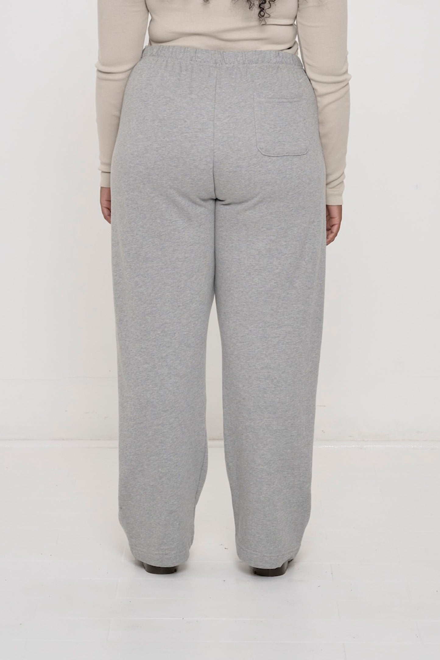 Back view: person in Heather Sweatpants. Relaxed fit throughout and a right back pocket.