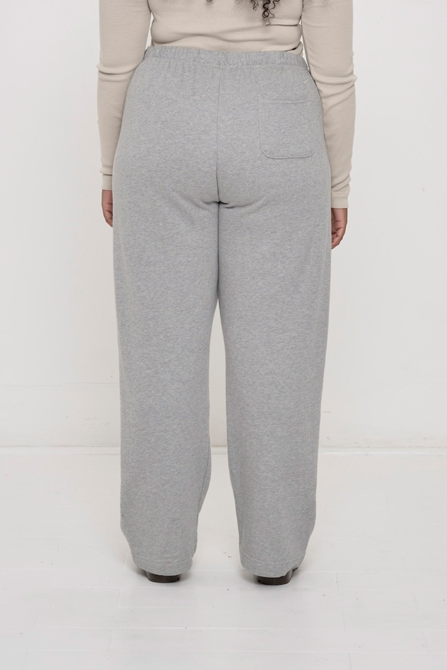 Back view: person in Heather Sweatpants. Relaxed fit throughout and a right back pocket.