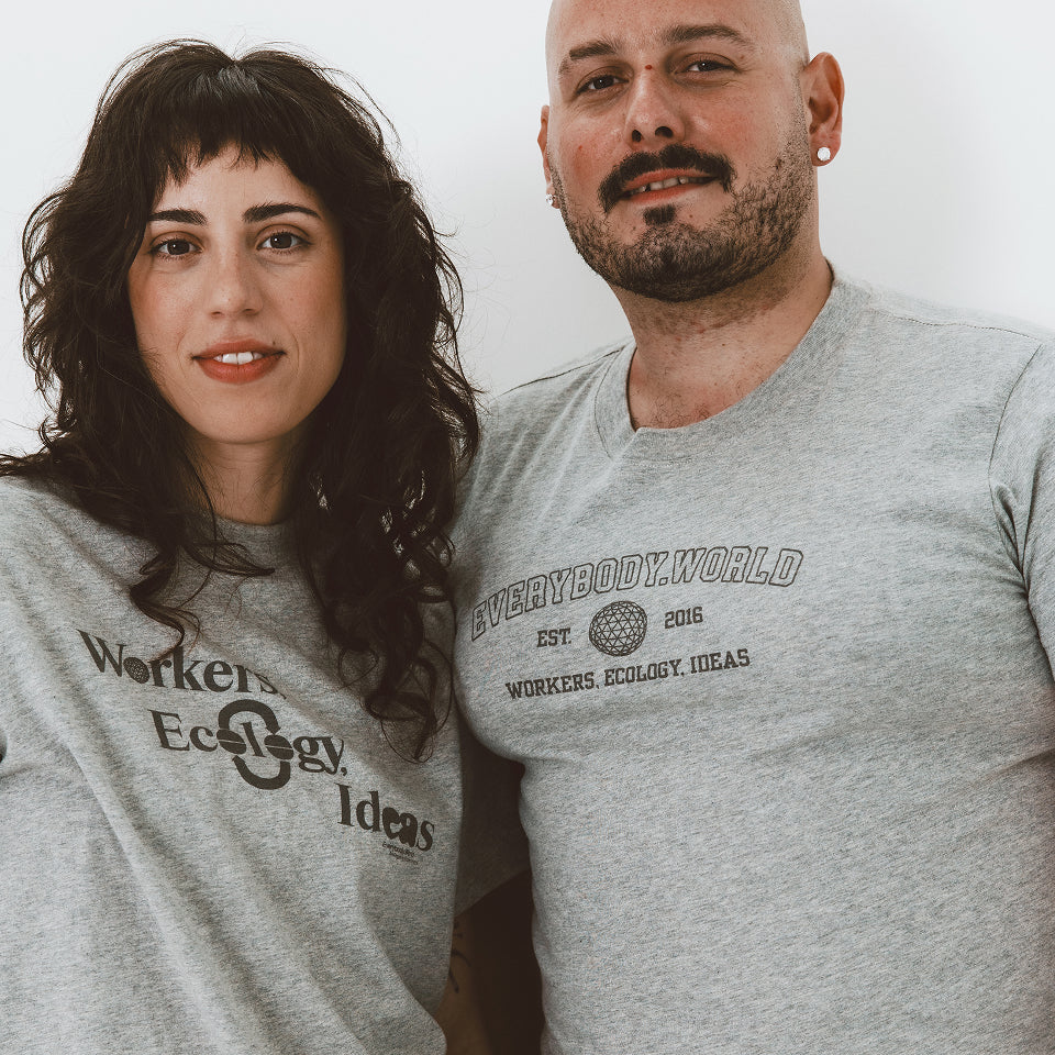 Two People smiling wearing Heather Boxier Tee and Heather Short Sleeve Tee with graphics on the tees.