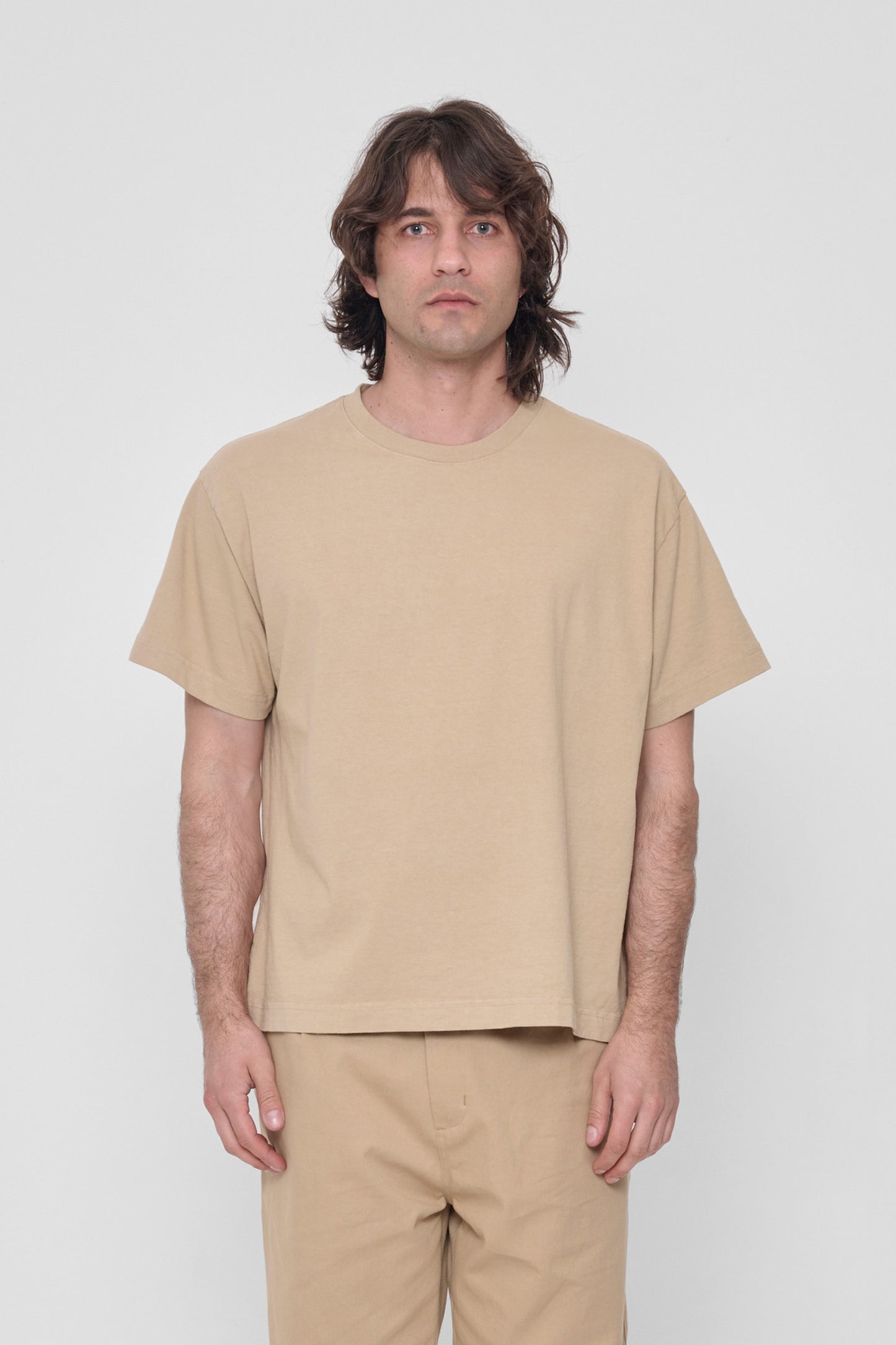 6'2" man wearing size L Sand Storm Heavyweight Boxier Trash Tee. Hem is at his middle hip.