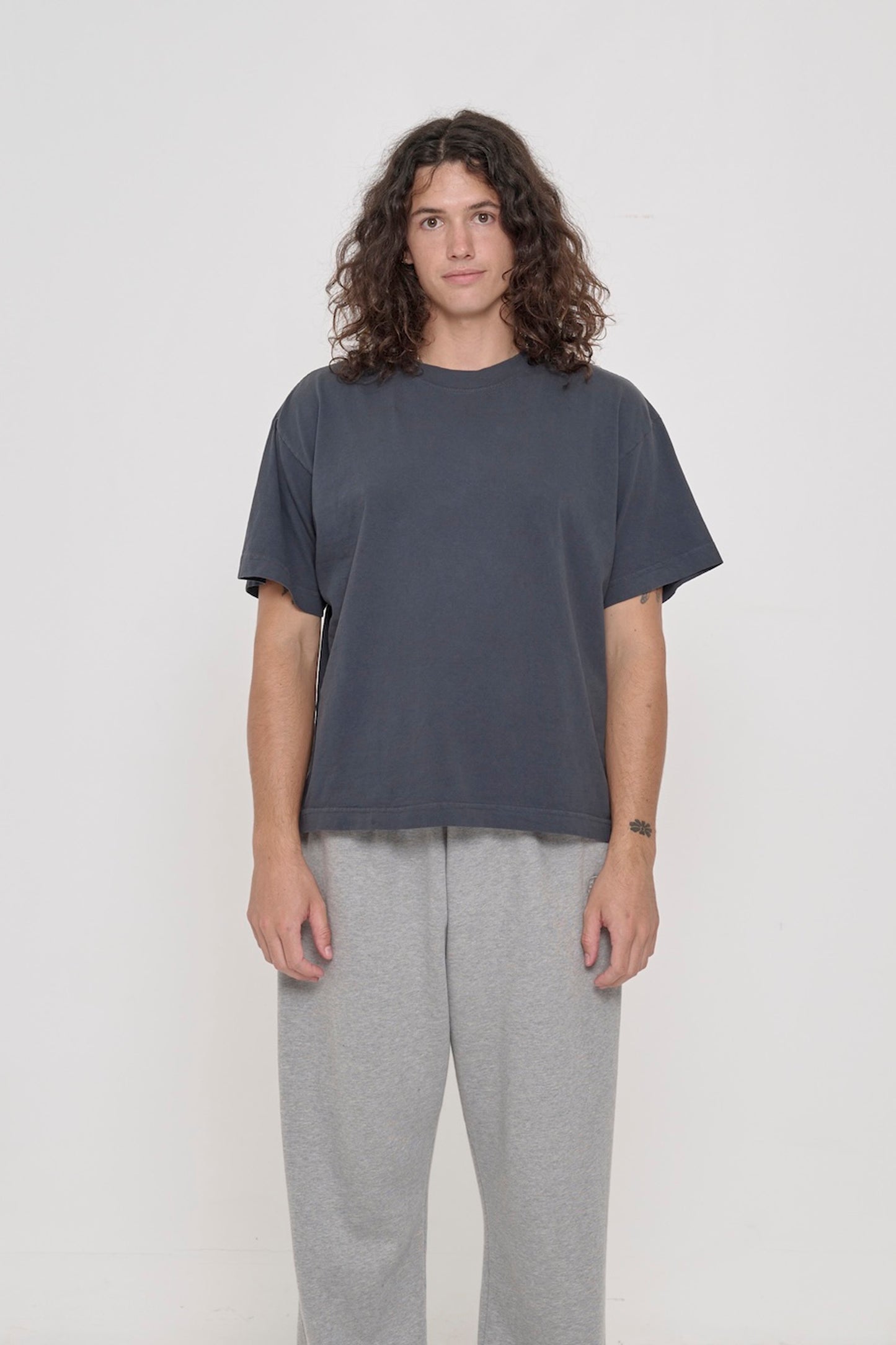A 6' tall person wearing a Slate Heavyweight Boxier Trash Tee in size M. Hem is at their mid hip.