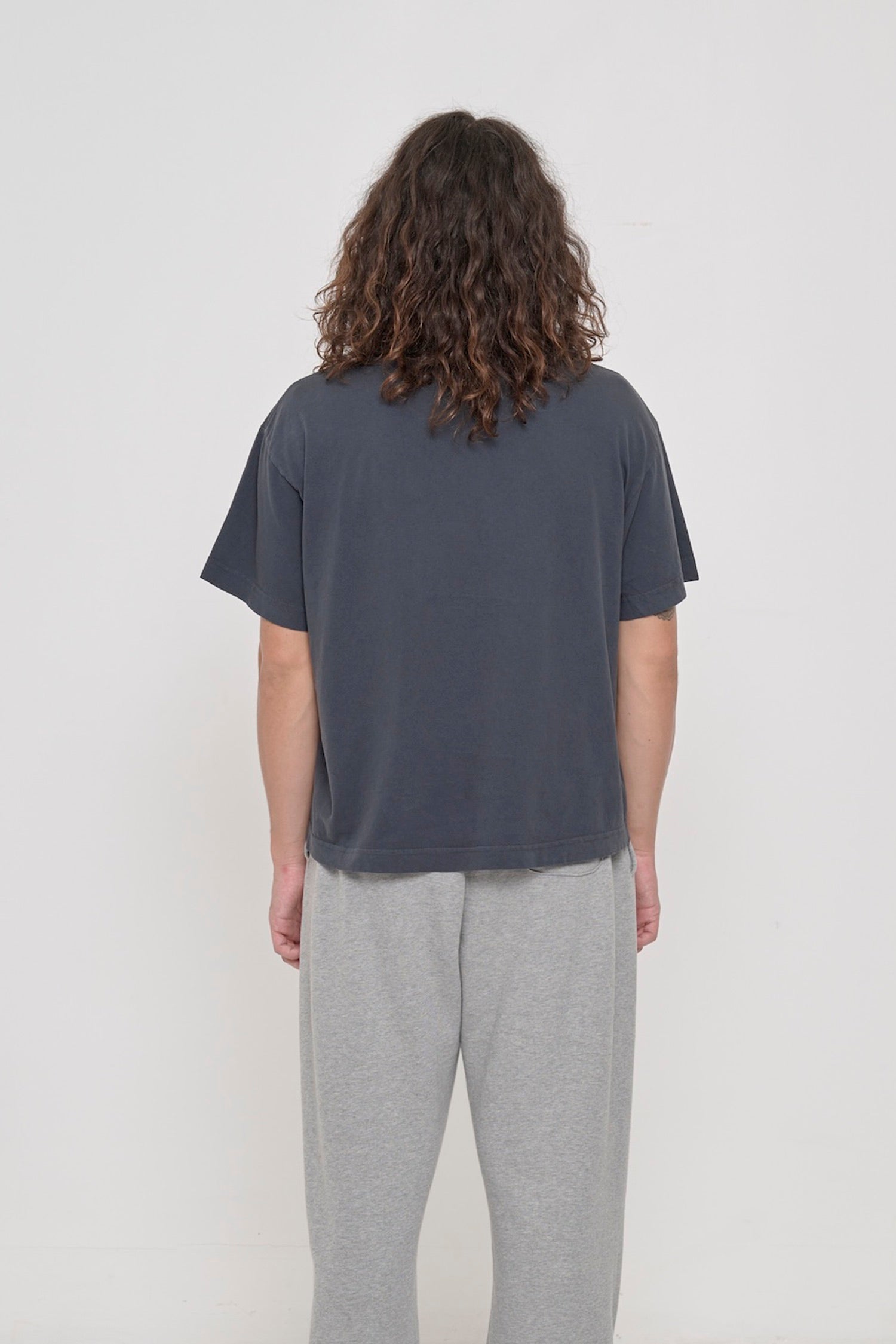 Back view: 6' tall person in a Slate Heavyweight Boxier Trash Tee showing fabric drape and relaxed fit throughout.