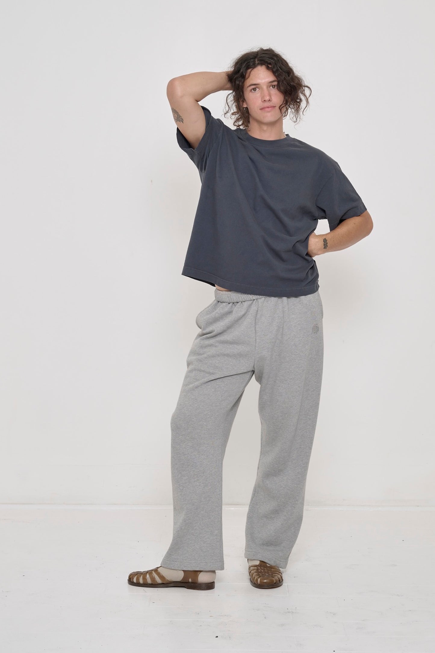 6' person in a Slate Heavyweight Boxier Trash Tee with Heather Sweatpants and Plasticana Sandana Jelly Sandal.