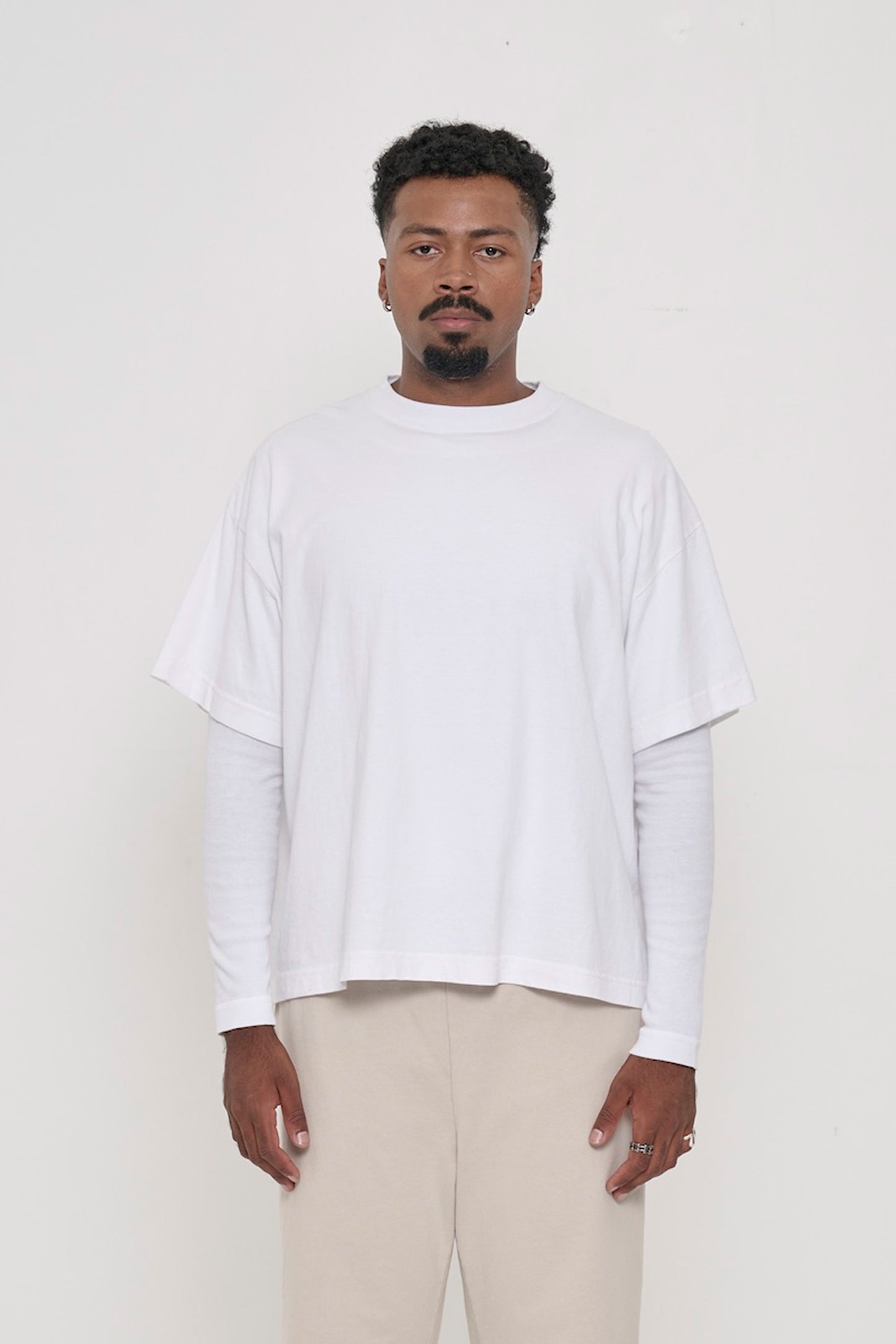 A 6'2" person in a White Heavyweight Boxier Trash Tee in size L. Hem is at lower mid hip.